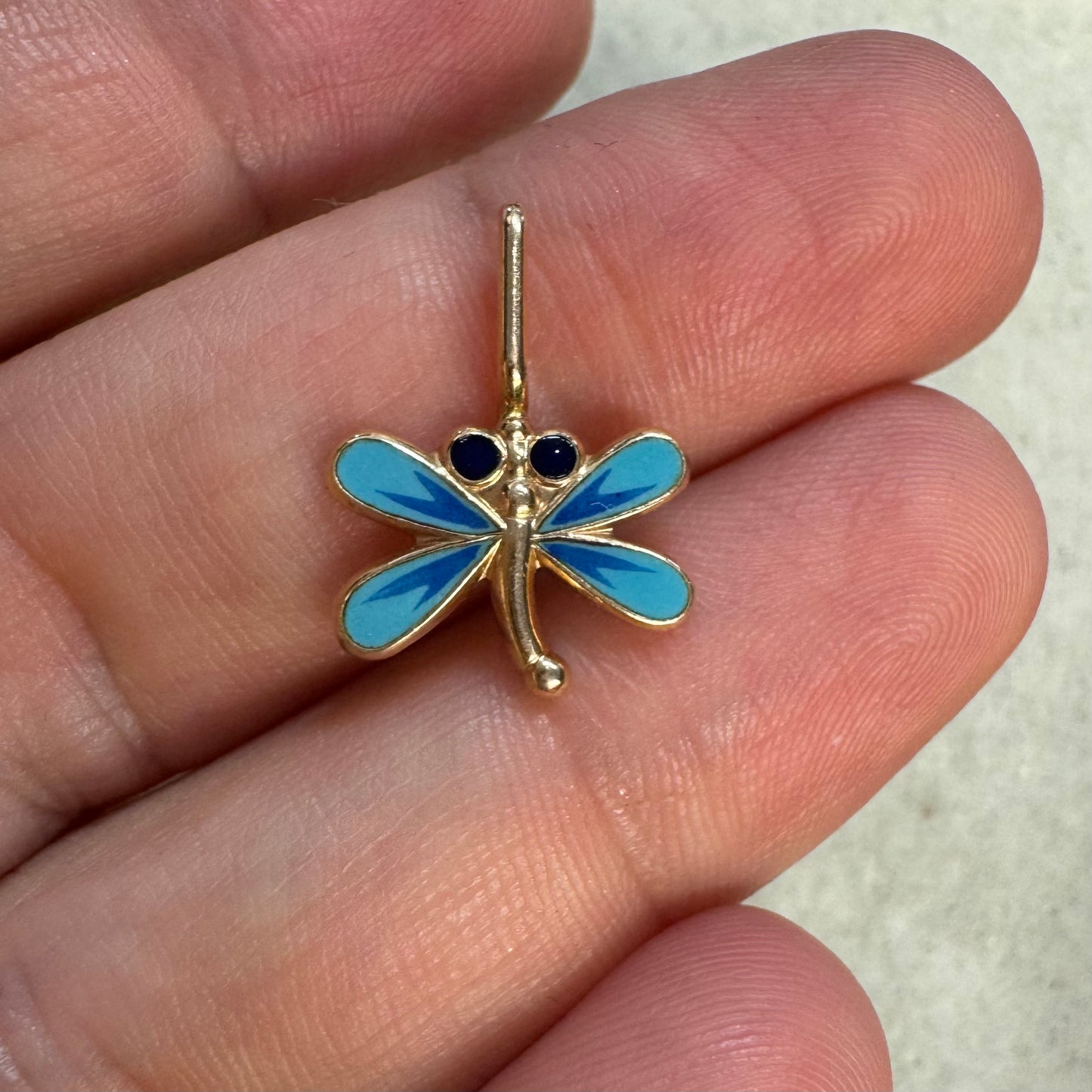 תליון זהב 14 קראט בעיצוב שפירית, עם עבודת אמייל כחולה ופרטים עדינים שמעניקים לו מראה צבעוני ואלגנטי.