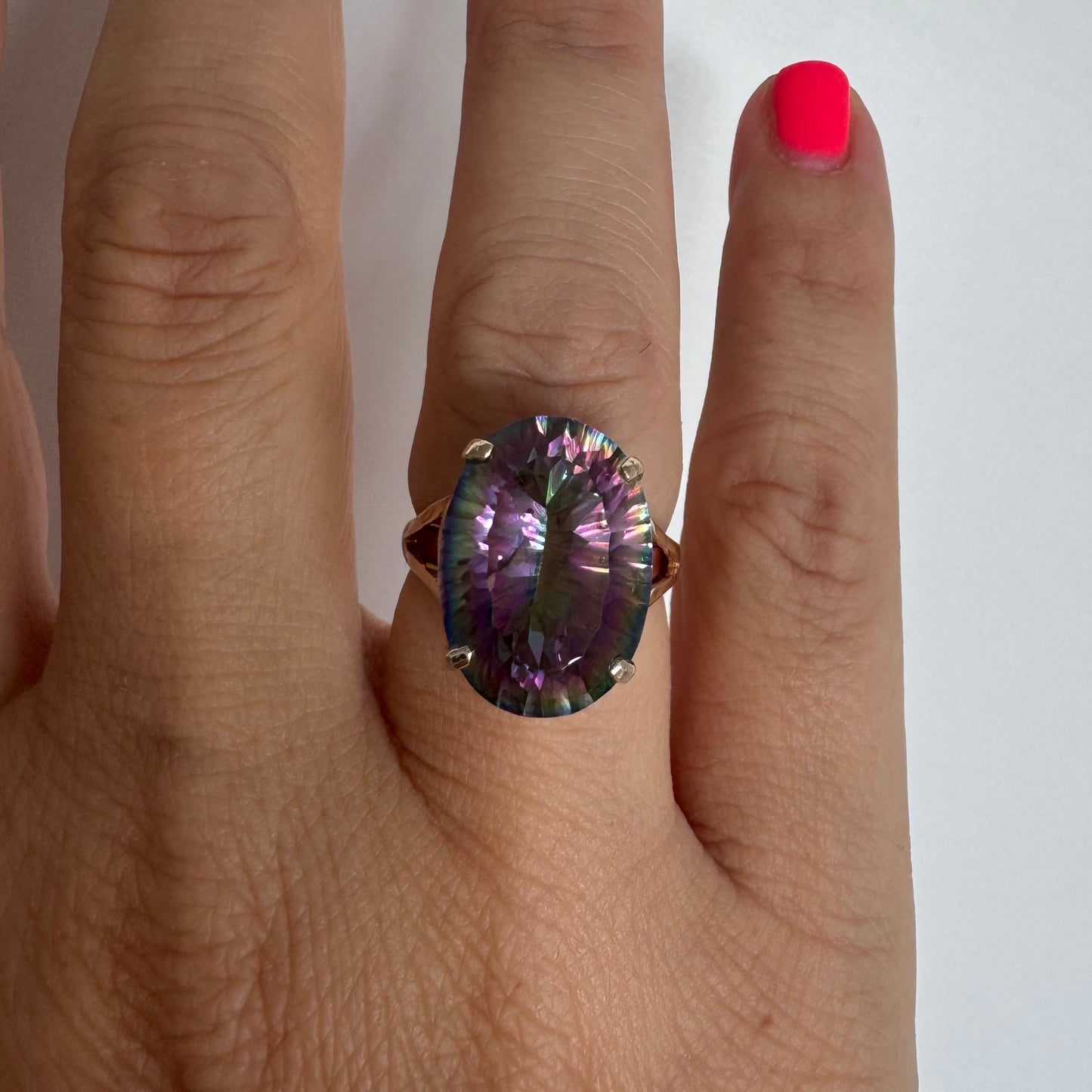 9K gold ring set with a large iridescent stone displaying mesmerizing shades of purple, green, and blue that shift beautifully in the light.