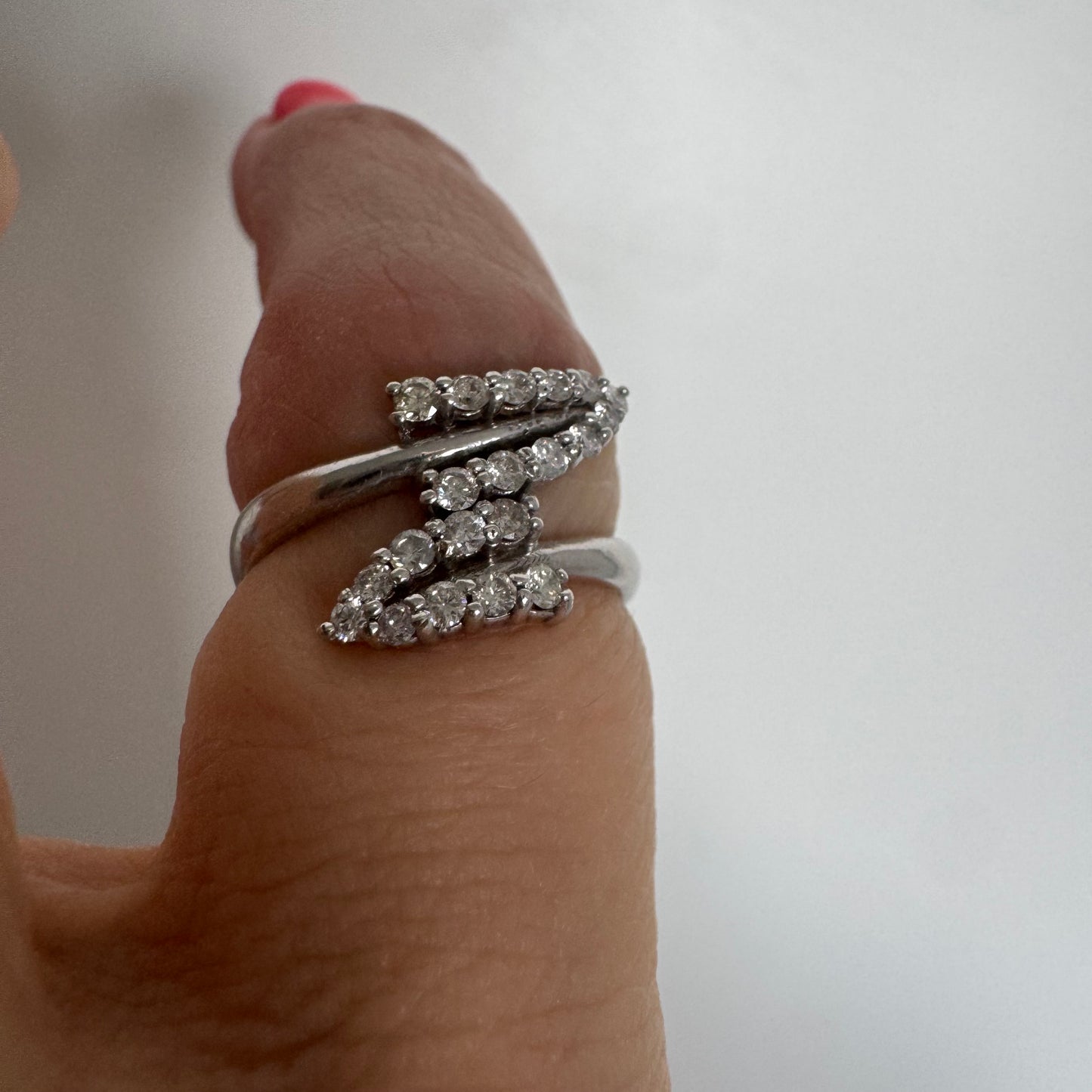 14K gold ring with an open design, featuring two curved rows of sparkling Diamonds that cross over each other elegantly.