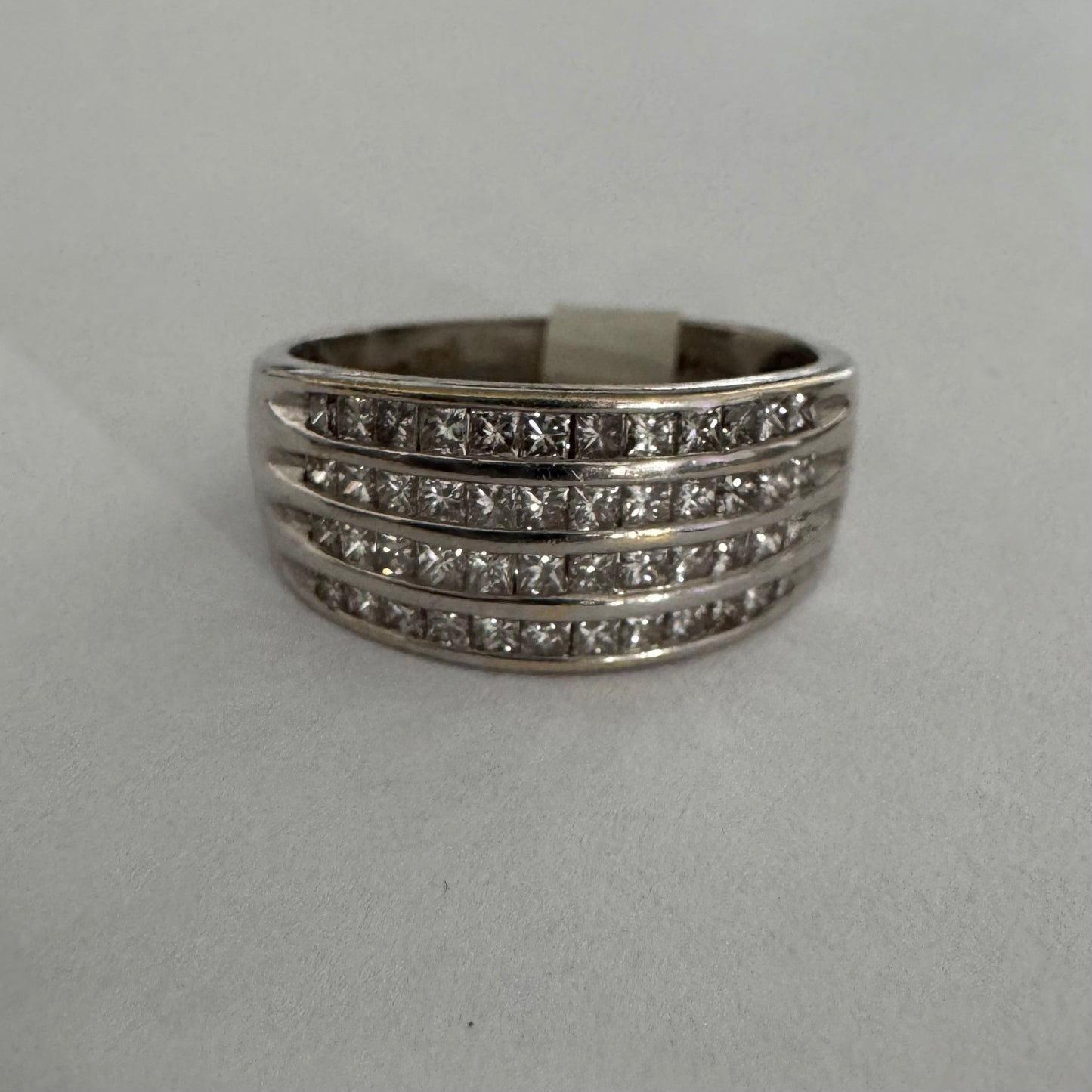 14K gold ring set with four parallel rows of princess-cut Diamonds.