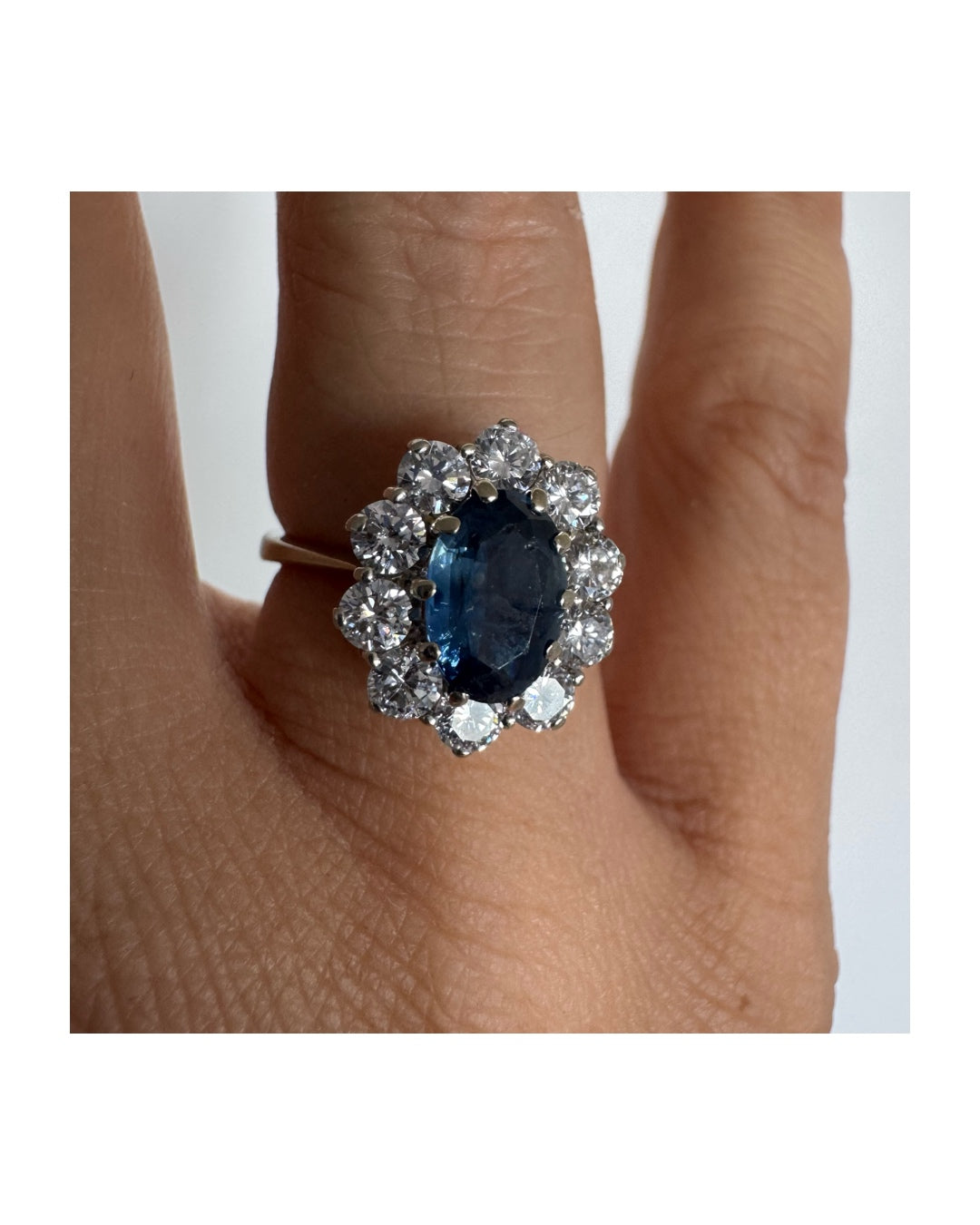 18K gold ring featuring a deep blue Sapphire at its center, surrounded by a sparkling halo of Diamonds