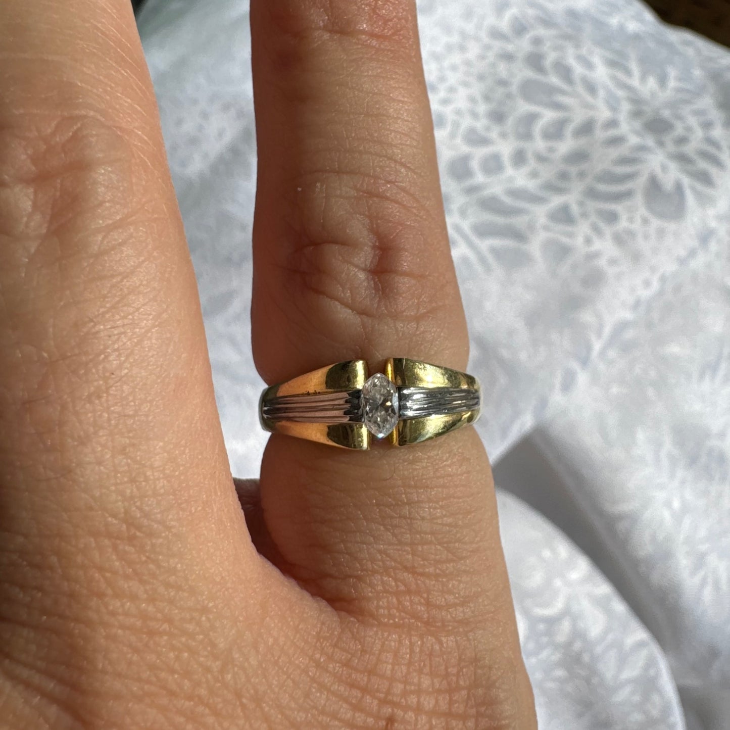 טבעת זהב 18 קראט בעיצוב דו-גוני של זהב צהוב ולבן, משובצת יהלום בחיתוך מרקיזה. 
