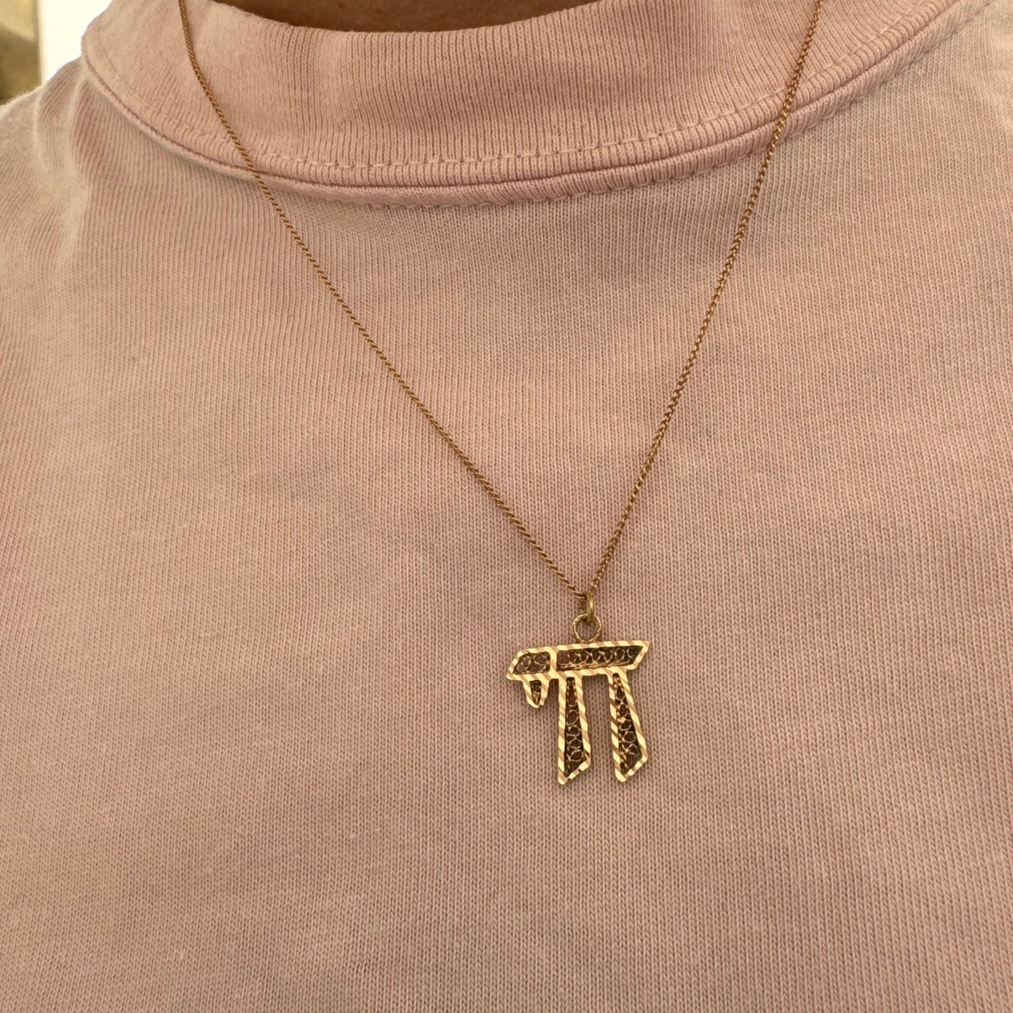 שרשרת זהב אדום 14 קראט עם תליון “חי״, בעיצוב גרפי ובעל נוכחות.