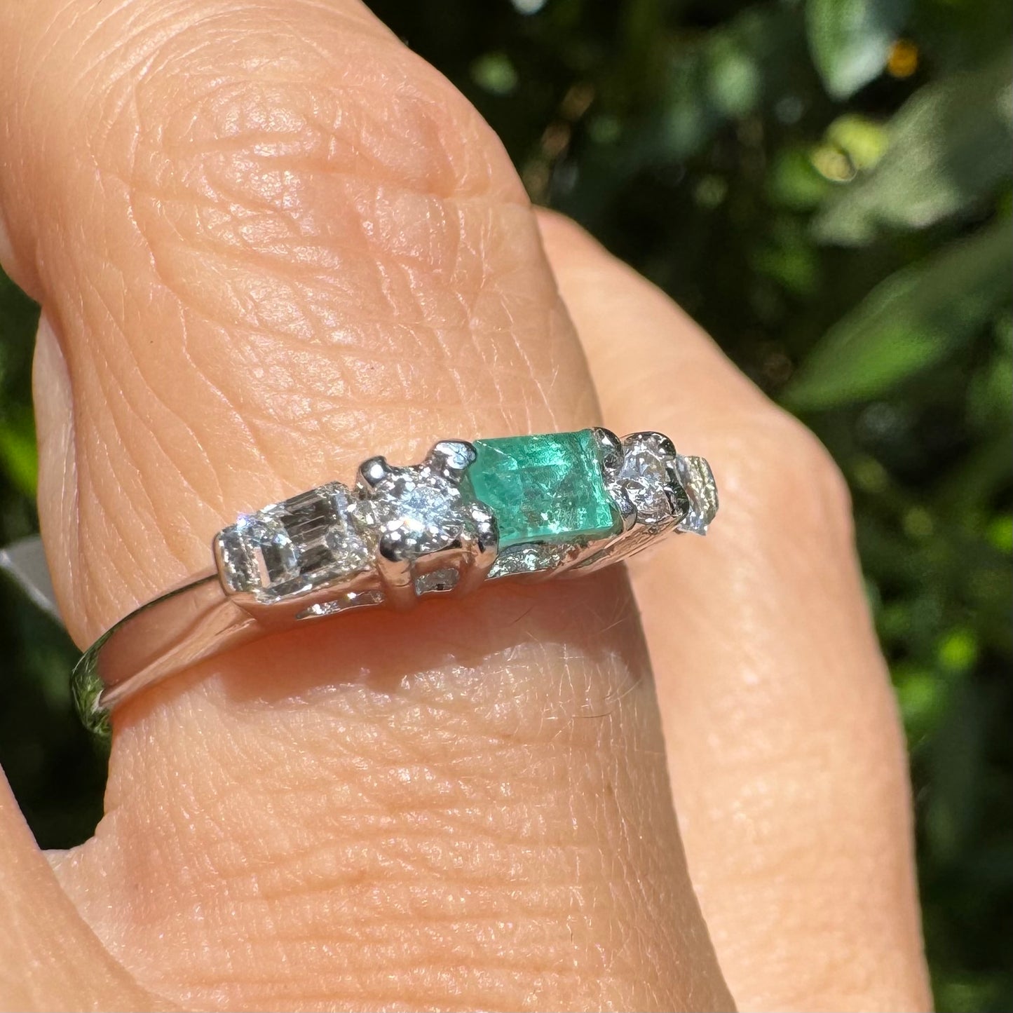 14K gold ring set with one center Emerald & Diamonds on the sides