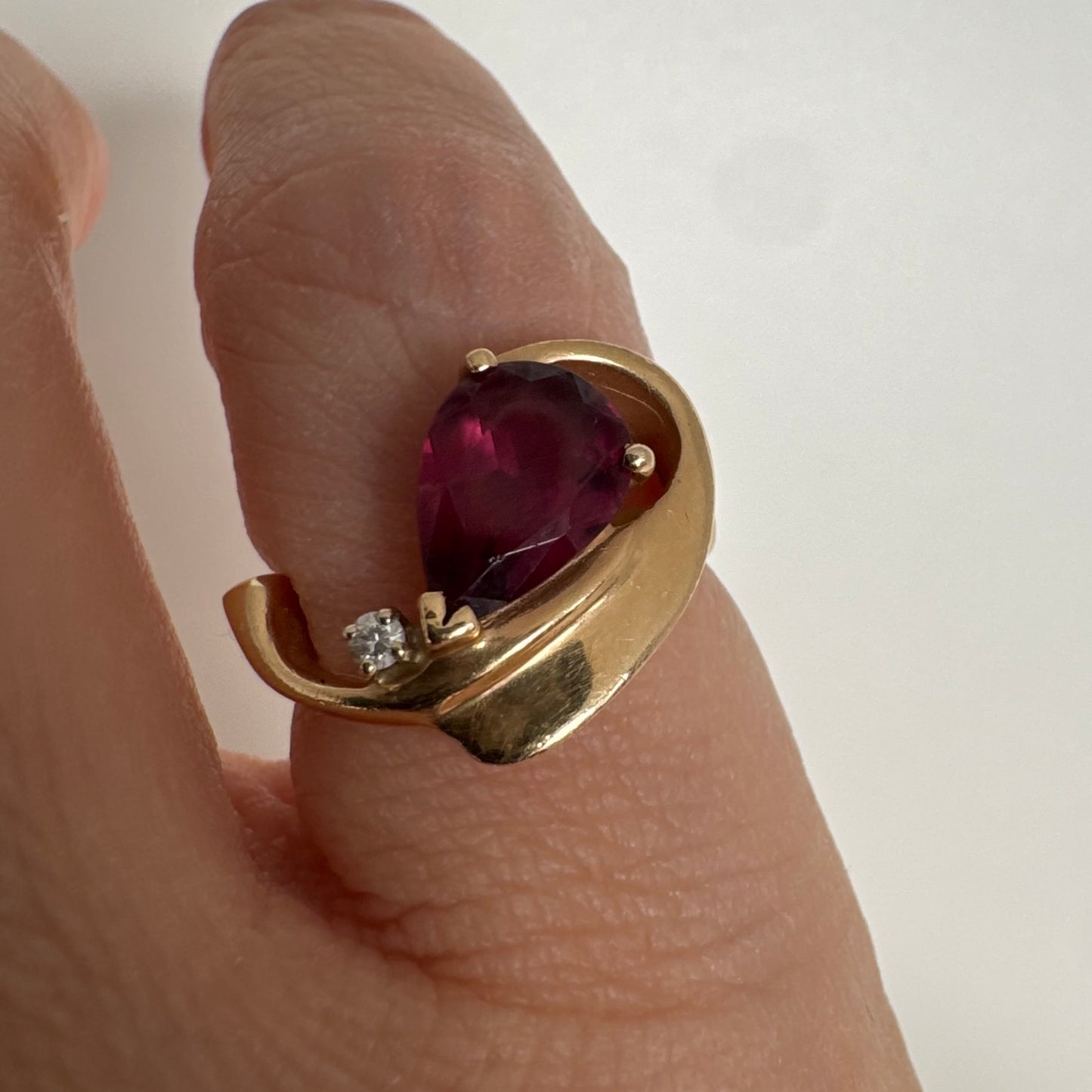 14K gold sculptural open ring set with a pear-cut pink Tourmaline, accented by a small Diamond.