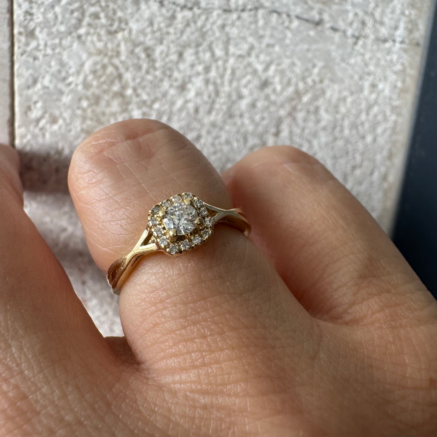 14K gold ring set with a central Diamond surrounded by small Diamonds
