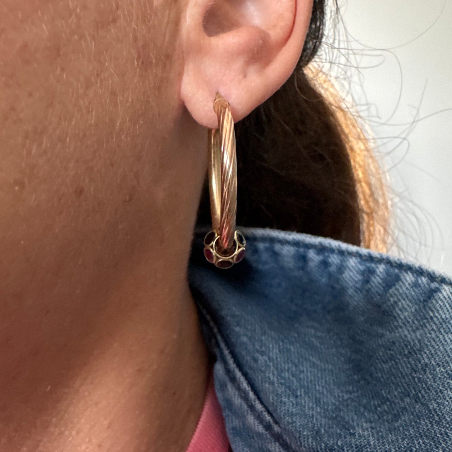 10K gold hoop earrings with a twisted design, set with pink and green Tourmaline.