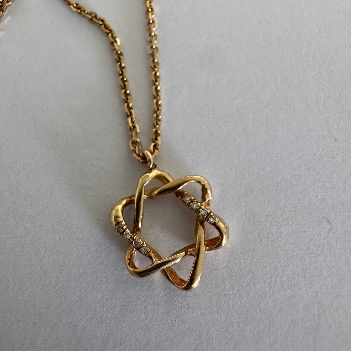 14K gold “Star of David” pendant with a sculptural open design.