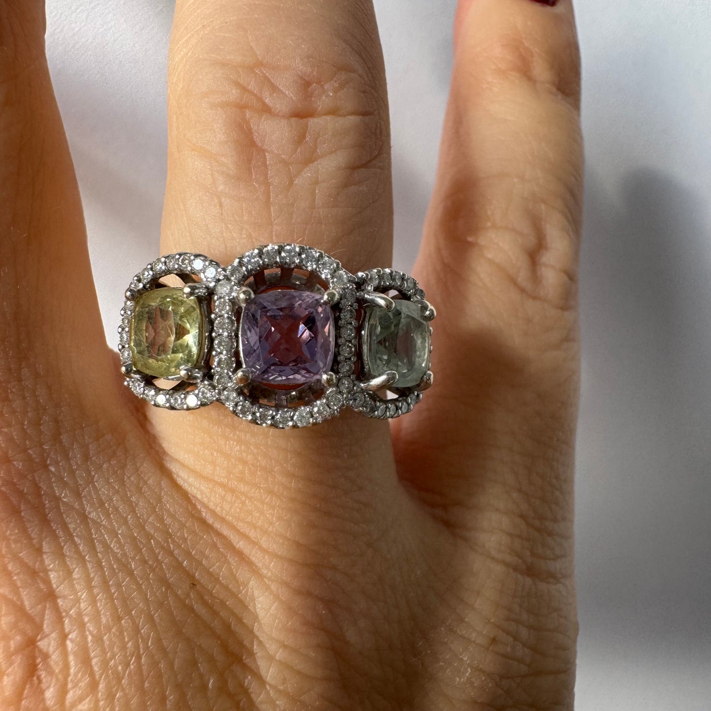 18K gold ring set with three pastel gemstones in soft shades of lilac, yellow and light gray