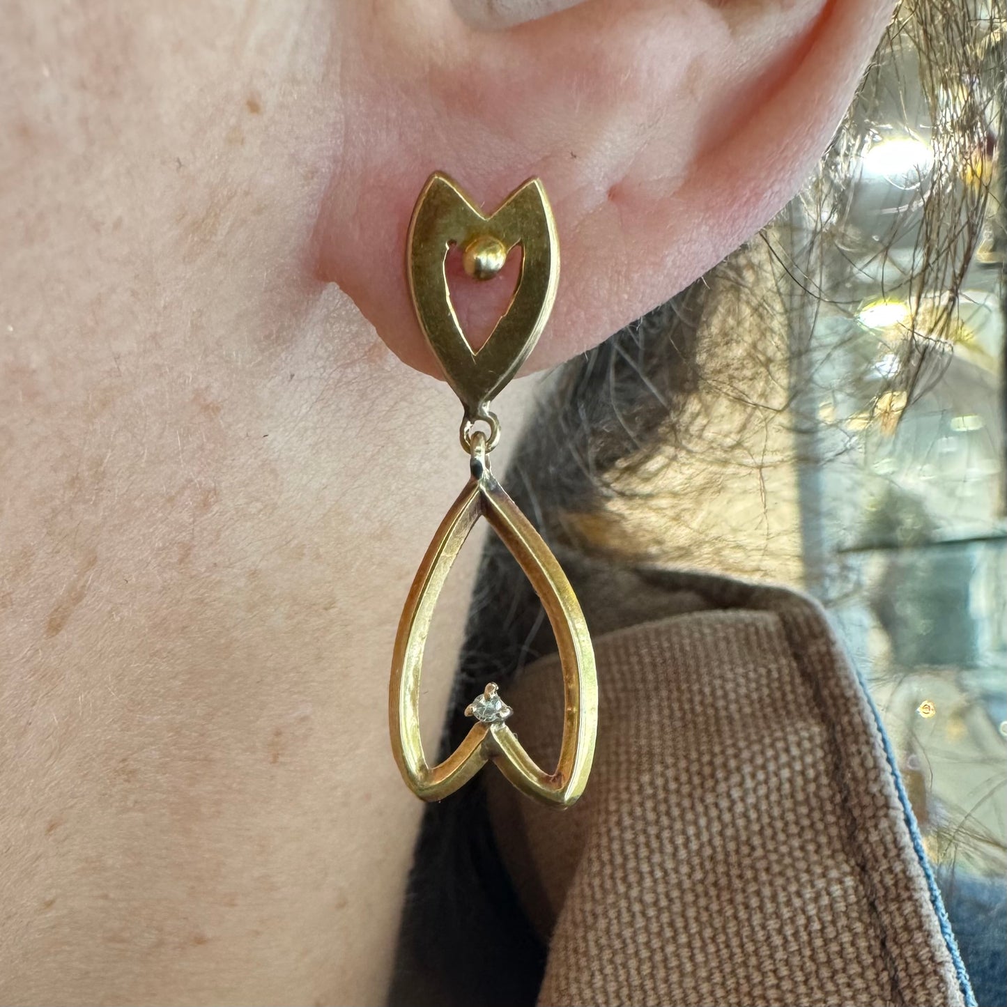 עגילי זהב צהוב 18 קראט בעיצוב עדין ומיוחד בצורת לב, עם יהלום קטן שמוסיף נצנוץ מדויק