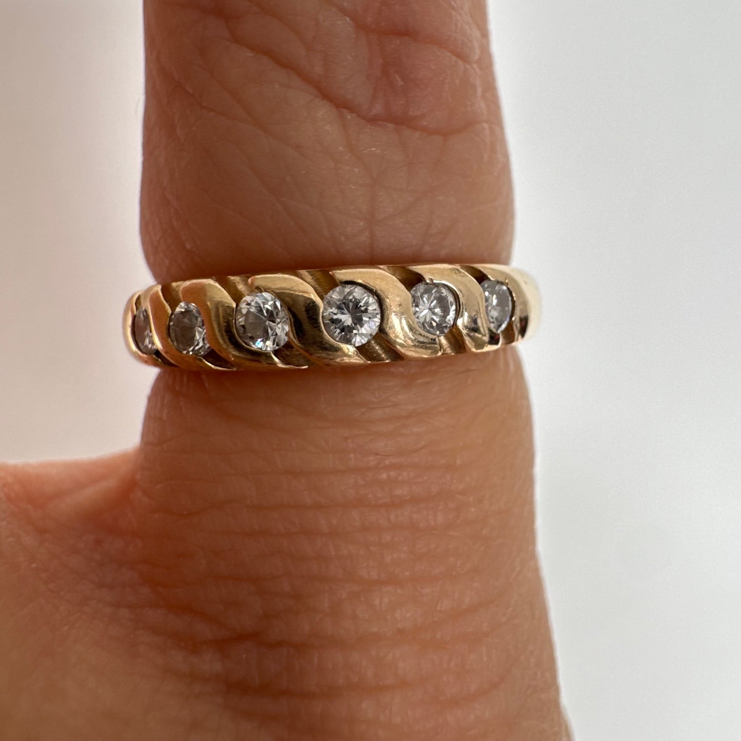 טבעת זהב צהוב 14 קראט משובצת יהלומים בחיתוך עגול, בשיבוץ מחורץ היוצר מראה ייחודי ומלא תנועה.