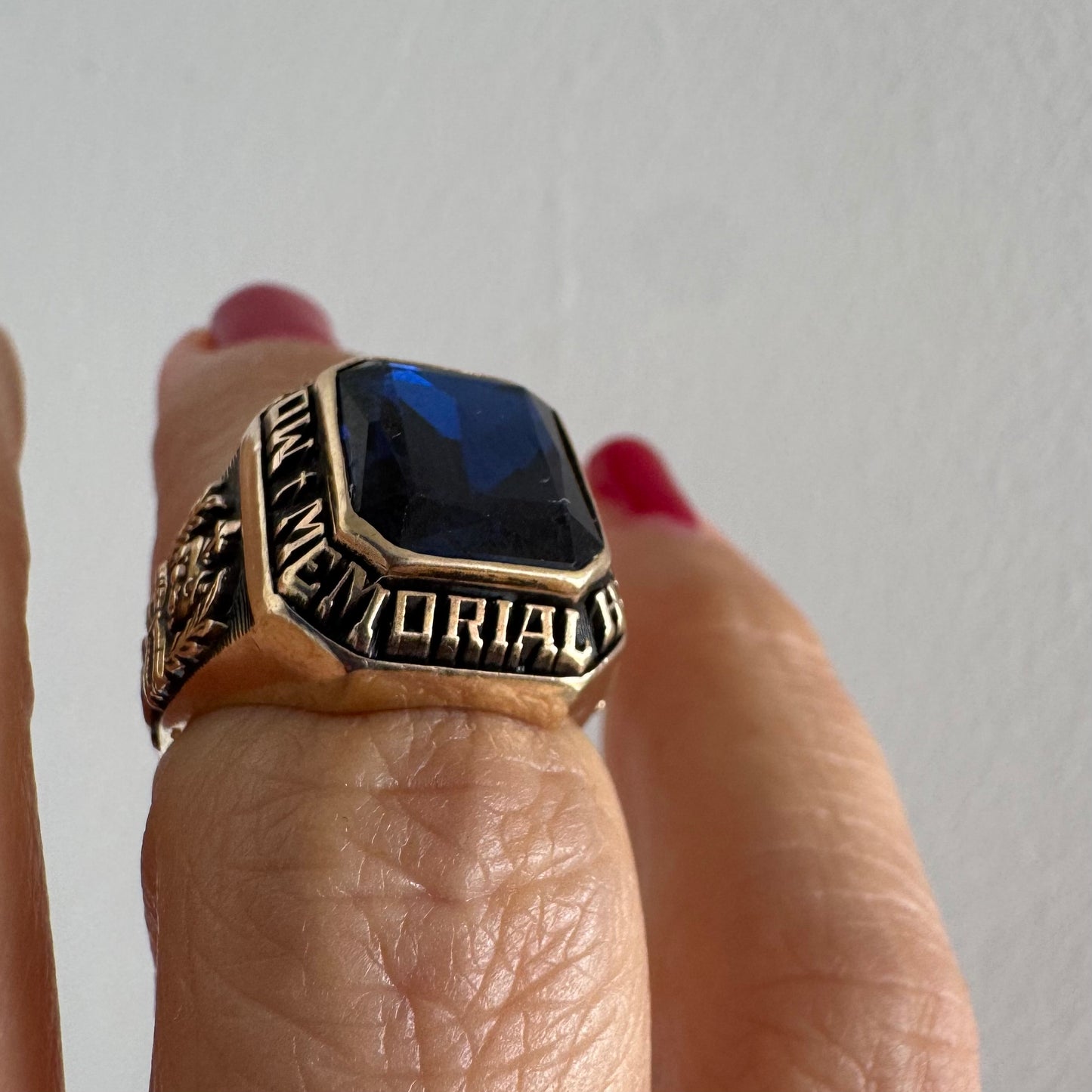 10K gold college ring set with a deep blue faceted stone.