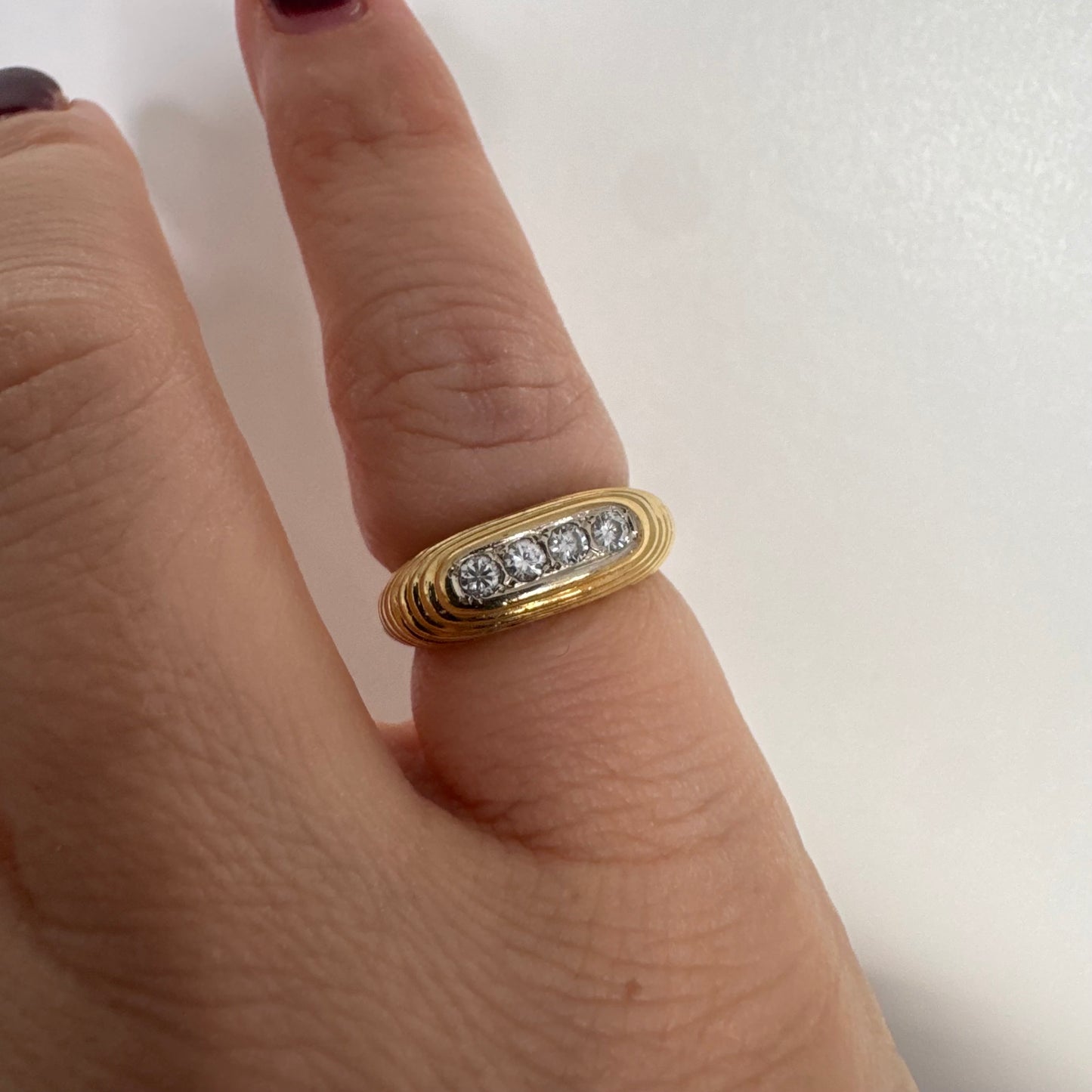 14K gold elongated oval ring set with five round Diamonds in a channel setting.