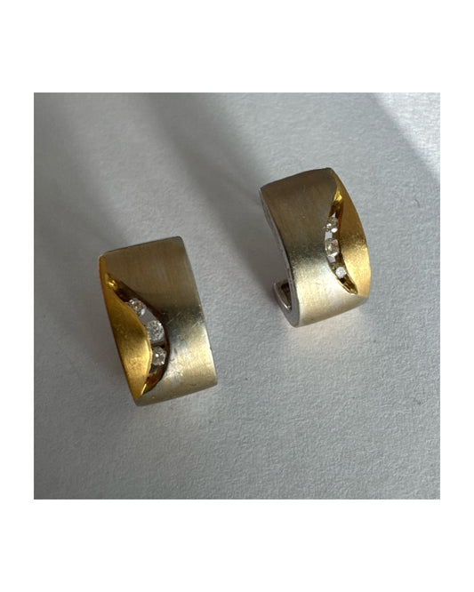 עגילי זהב 18 קראט משובצים יהלומים בעיצוב מודרני ונקי עם שילוב של שני גוונים וגימור מאט יוקרתי.