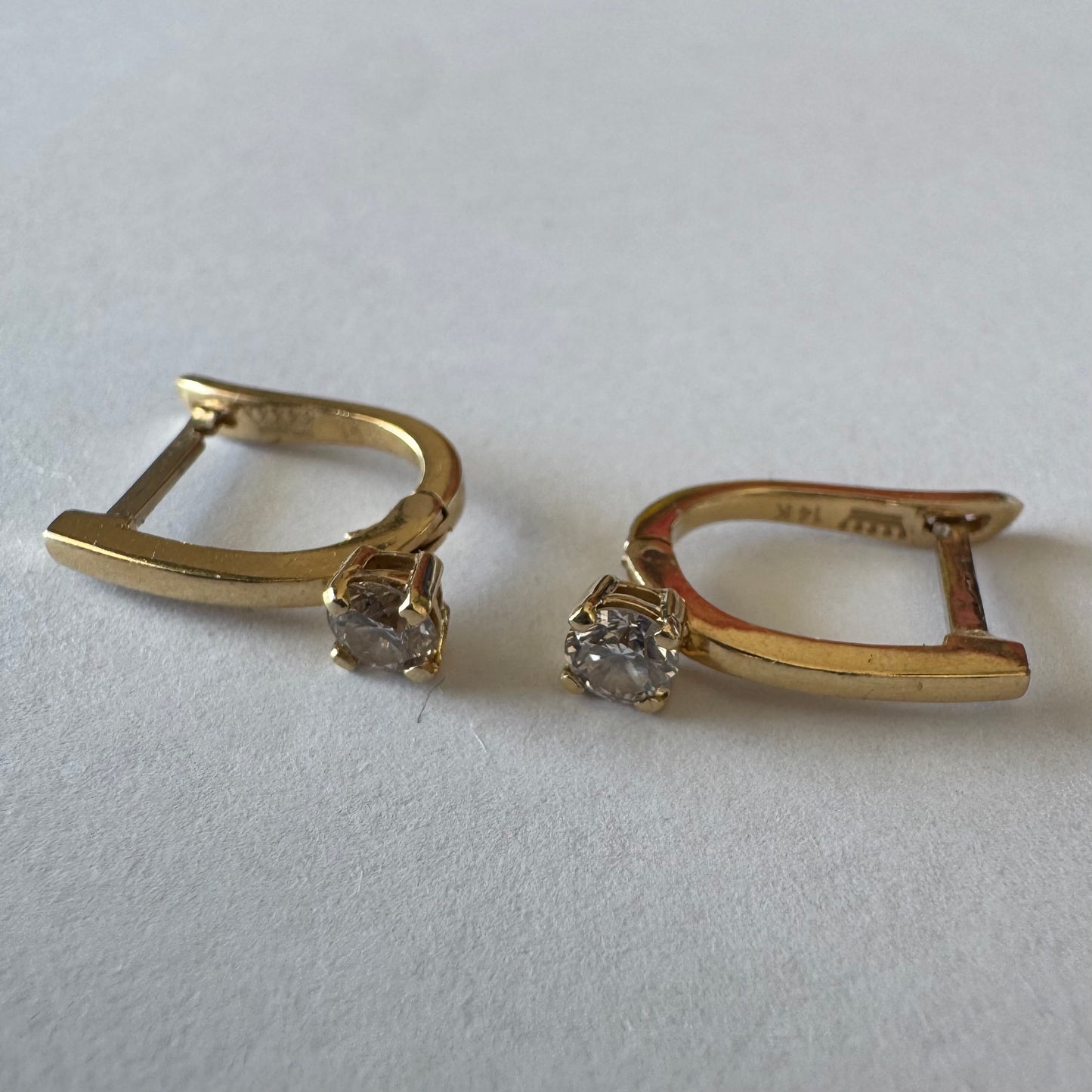 14K gold earrings set with round brilliant-cut Diamonds.