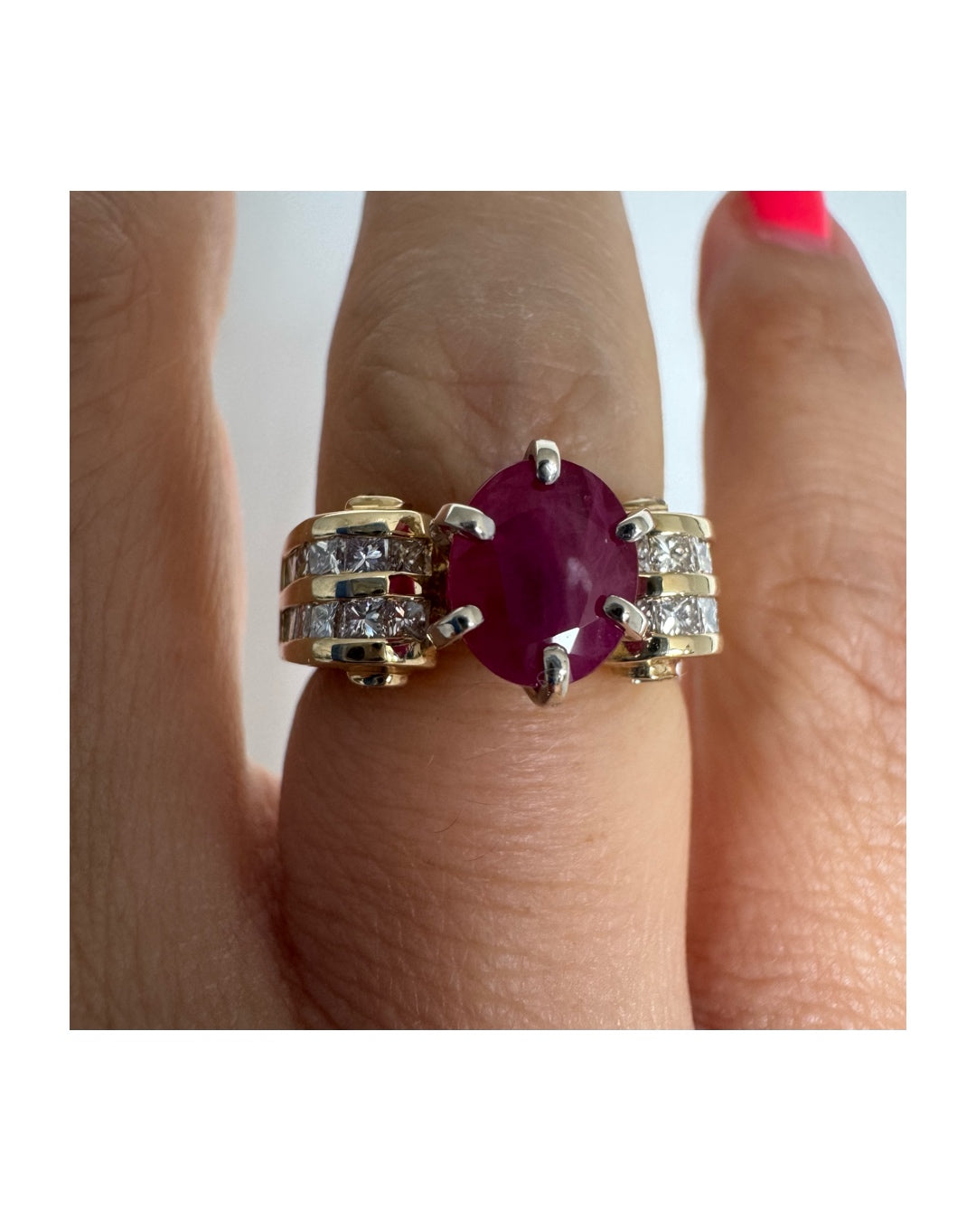 14K gold ring set with a vivid natural Ruby at the center and accented by rows of Diamonds on both sides.