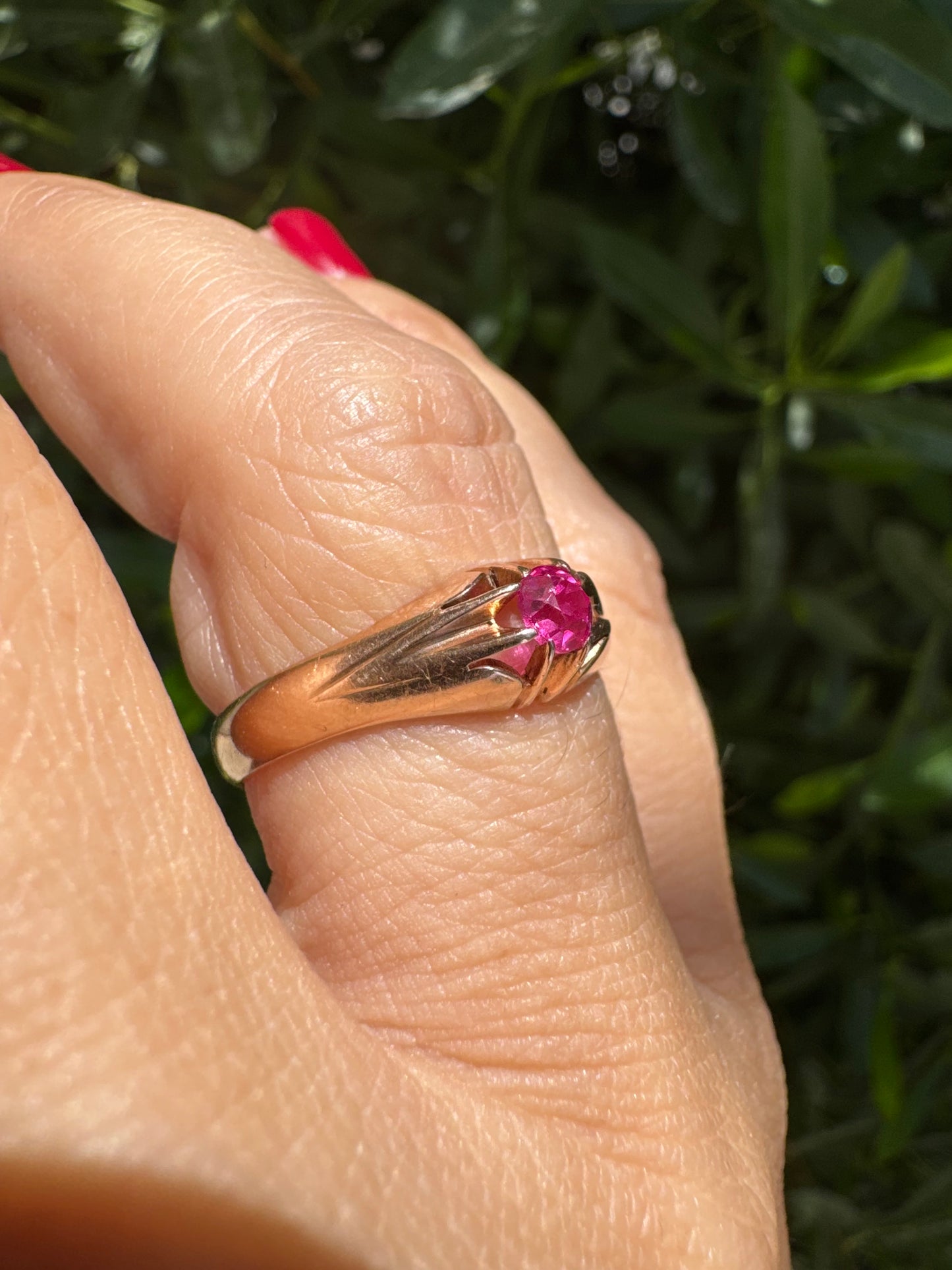 14K gold ring set with a vivid pink round-cut Ruby