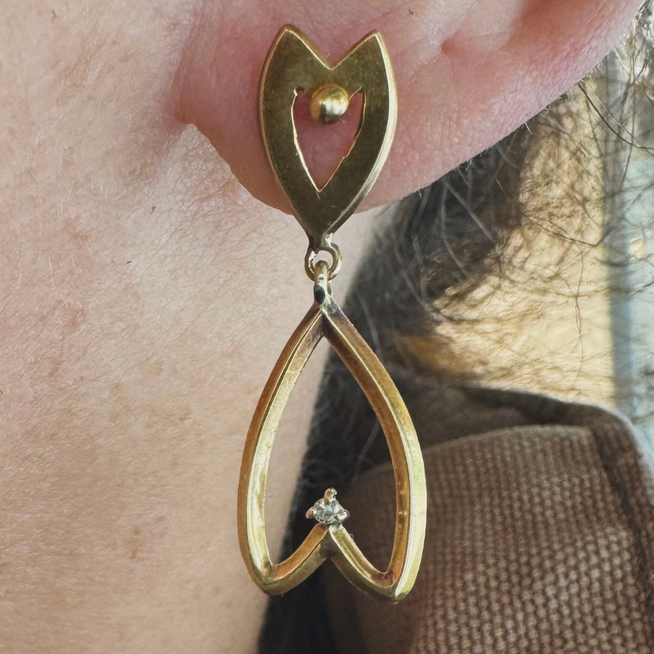 עגילי זהב צהוב 18 קראט בעיצוב עדין ומיוחד בצורת לב, עם יהלום קטן שמוסיף נצנוץ מדויק