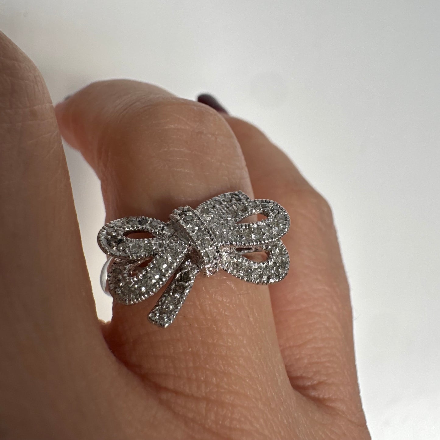 טבעת זהב לבן 14 קראט מעוצבת בצורת פפיון ומשובצת יהלומים בשיבוץ פאבה צפוף.