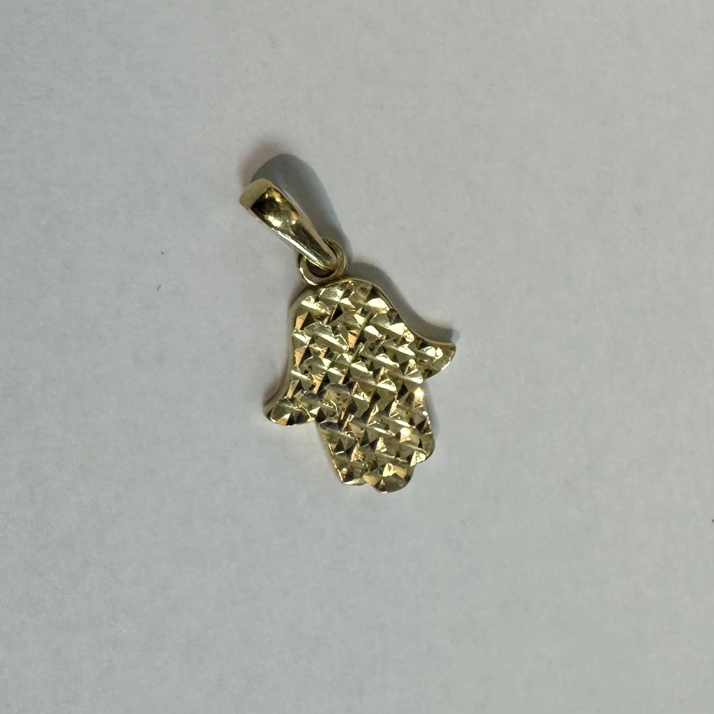 14K gold Hamsa pendant featuring a richly textured, light-catching finish.