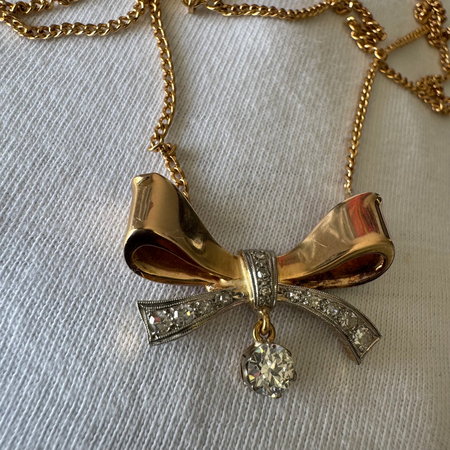 שרשרת זהב 18 קראט עם תליון בצורת סרט קלאסי משובץ יהלומים ונושא יהלום מרכזי תלוי שמוסיף נגיעה של זוהר ואלגנטיות