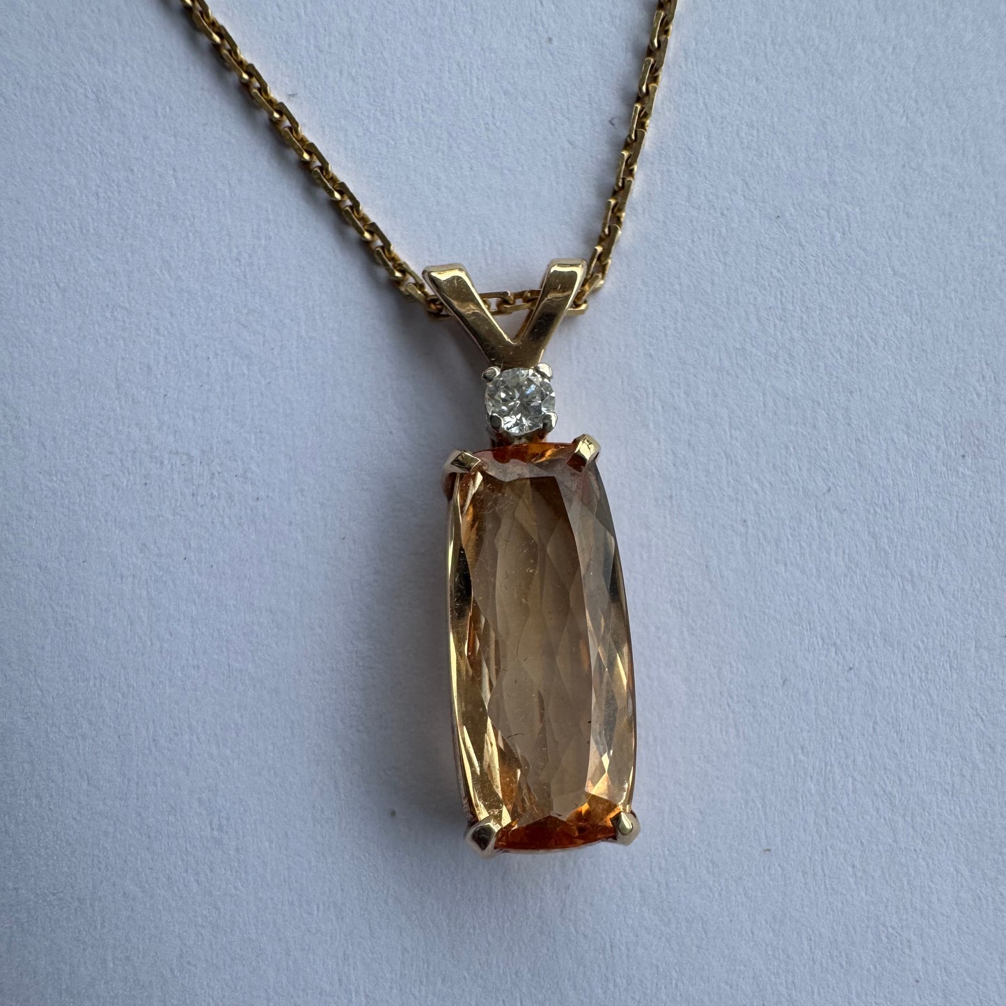 שרשרת זהב 14 קראט עם תליון זהב 14 קראט משובץ אבן קוורץ מלבנית בגוון שמפניה חמים, ומעליה יהלום נוצץ להדגשה עדינה של הברק.