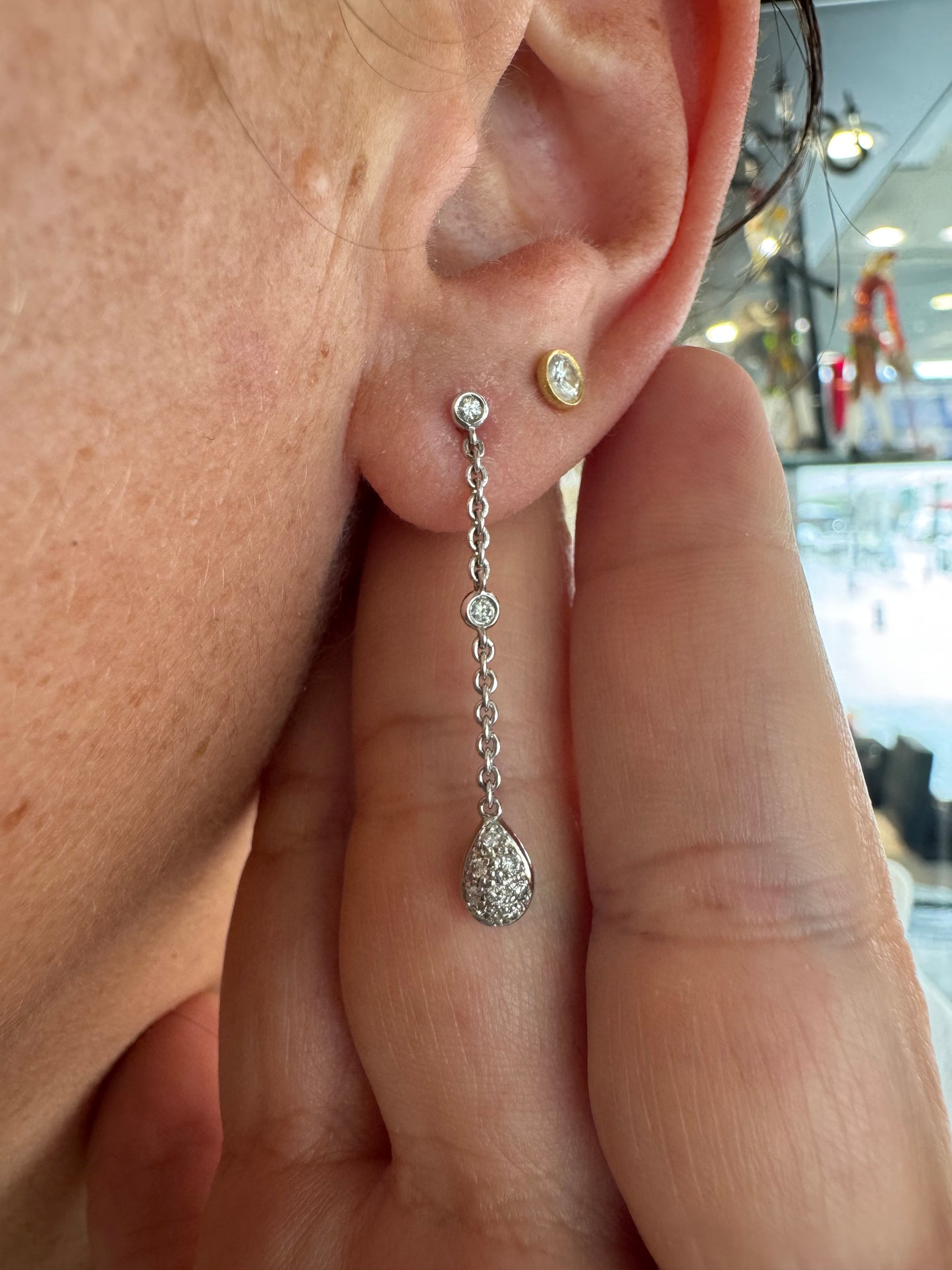 14K gold drop earrings featuring a delicate chain design with sparkling teardrop pendants.