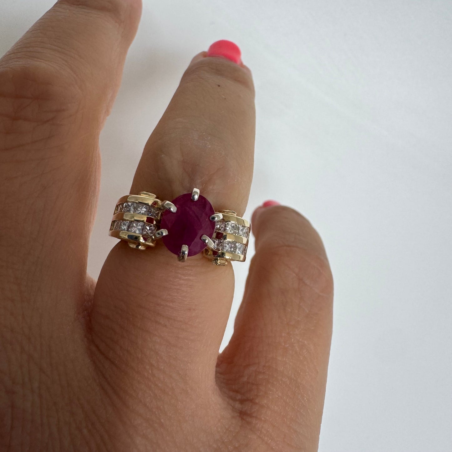 14K gold ring set with a vivid natural Ruby at the center and accented by rows of Diamonds on both sides.