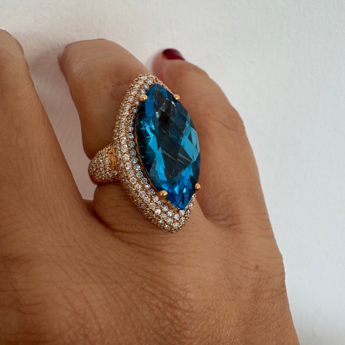 18K gold ring set with a large marquise-cut Blue Topaz gemstone, surrounded by sparkling Diamonds