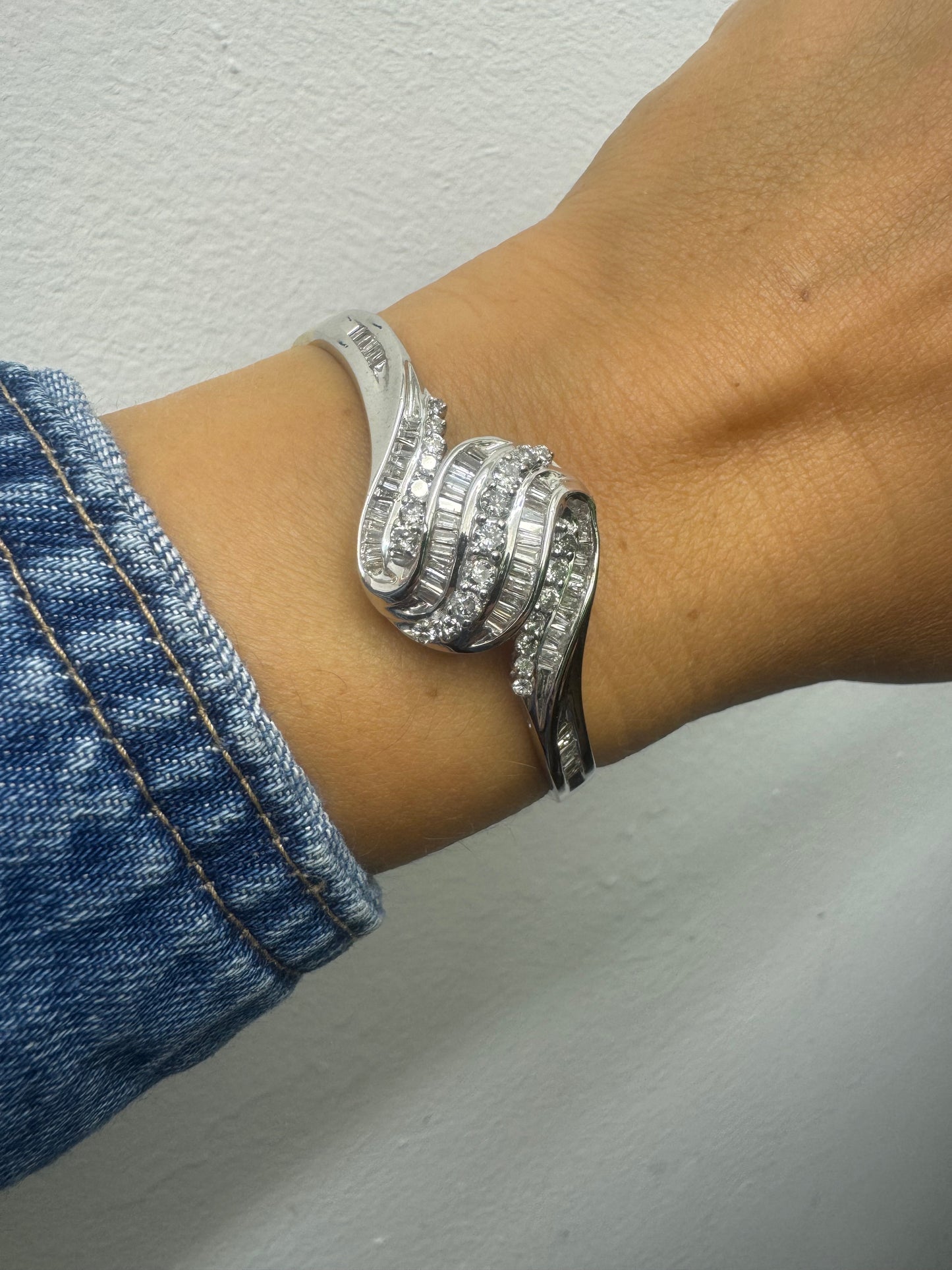 14K gold Hard bracelet featuring a flowing wave design, set with a dazzling mix of round and baguette-cut Diamonds
