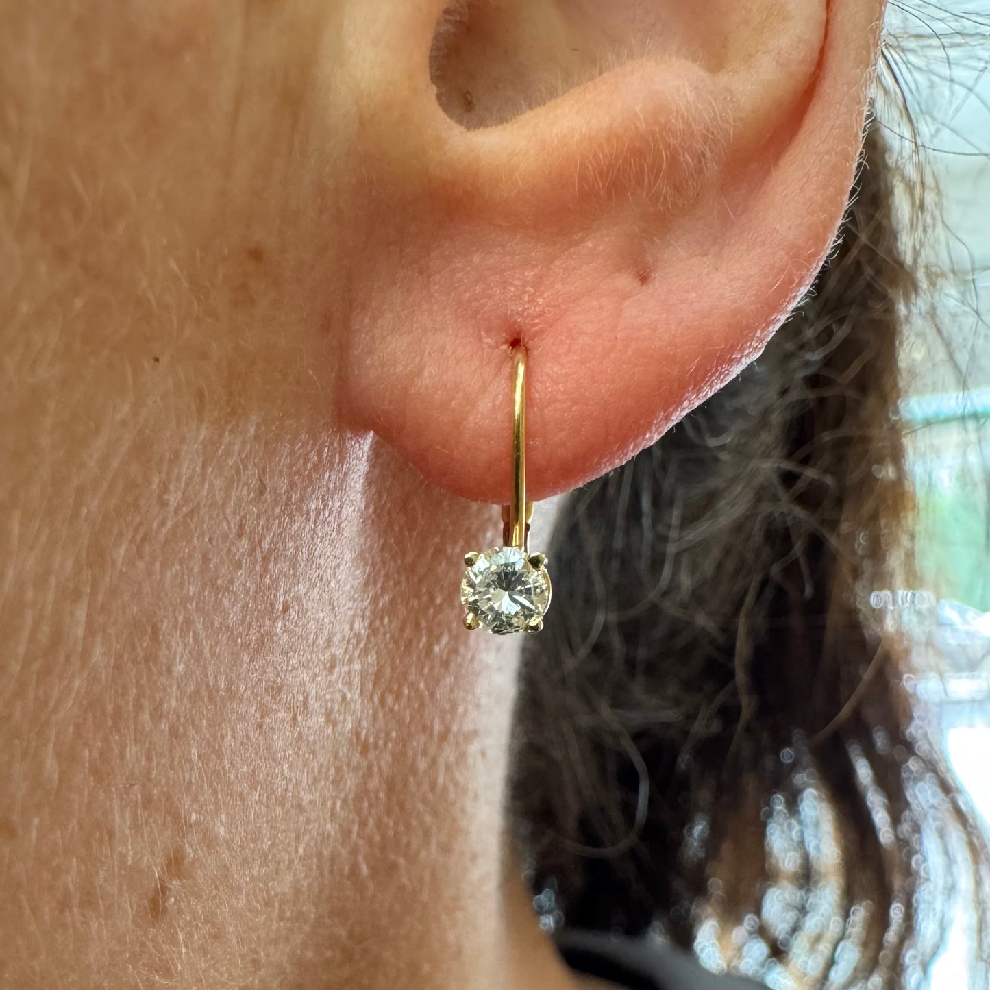 עגילי זהב 14 קראט משובצים יהלום עגול בשיבוץ קלאסי שמדגיש את האור והניקיון של האבן. 