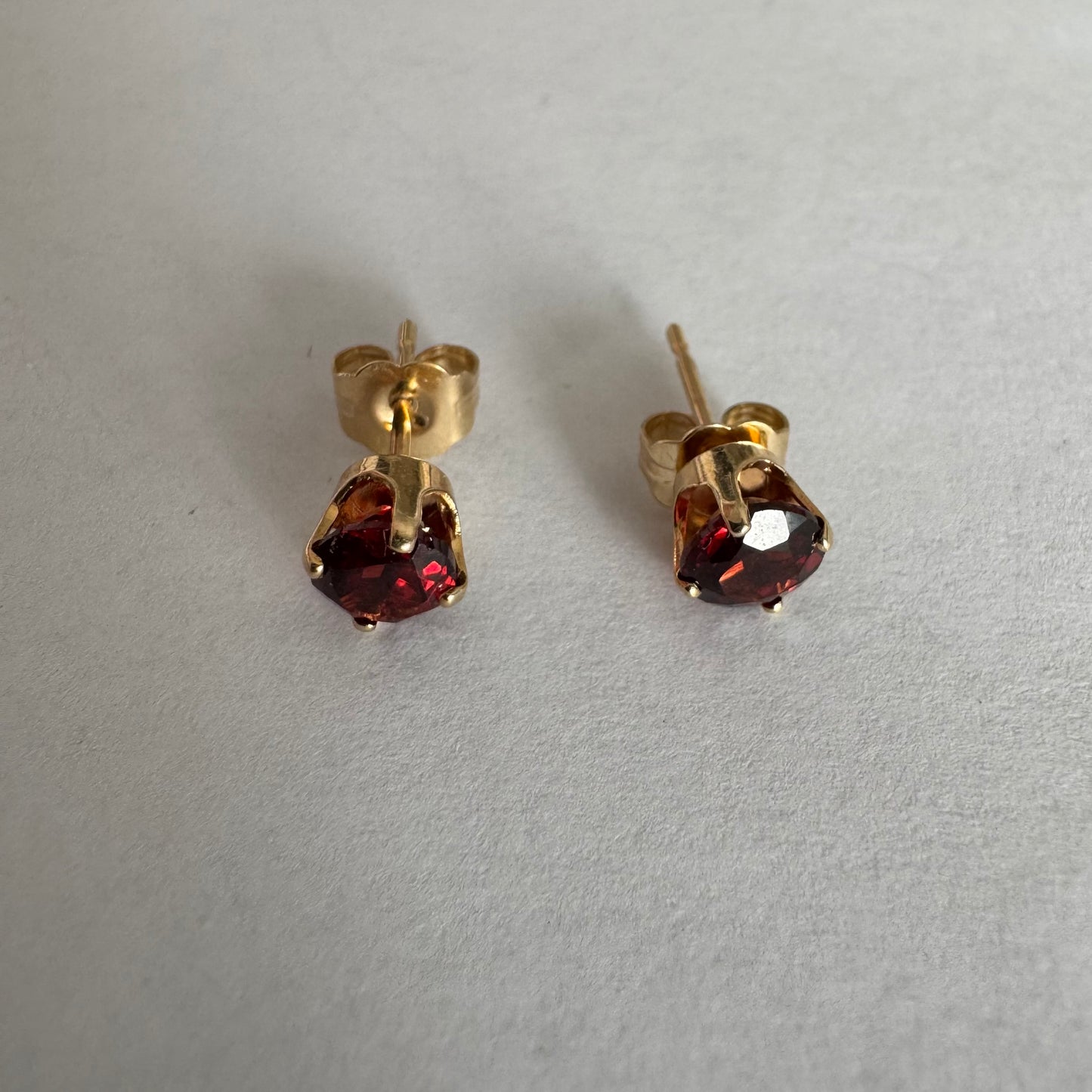 עגילי זהב 14 קראט משובצים אבני גרנט בגוון אדום יין עמוק.