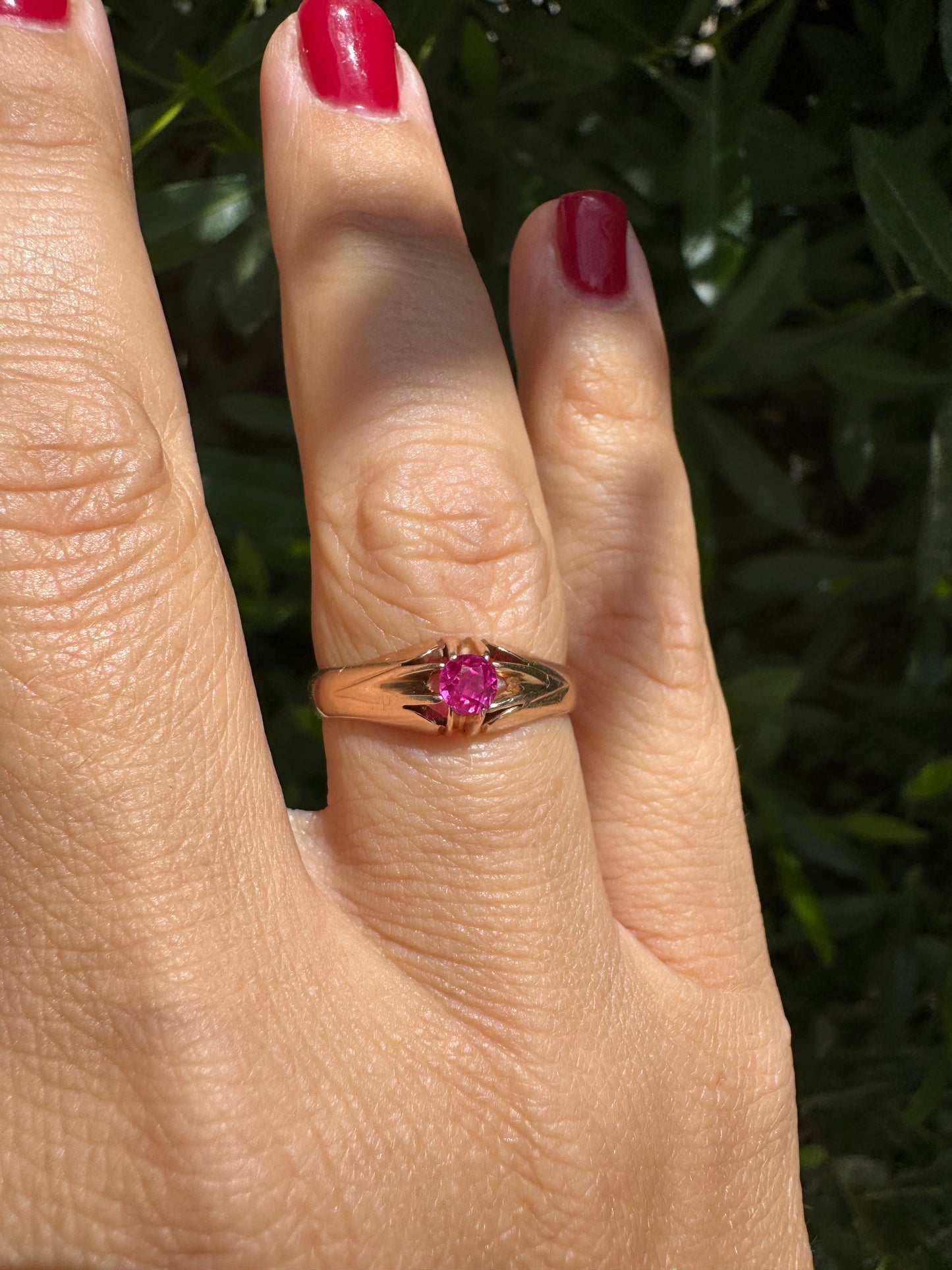 14K gold ring set with a vivid pink round-cut Ruby