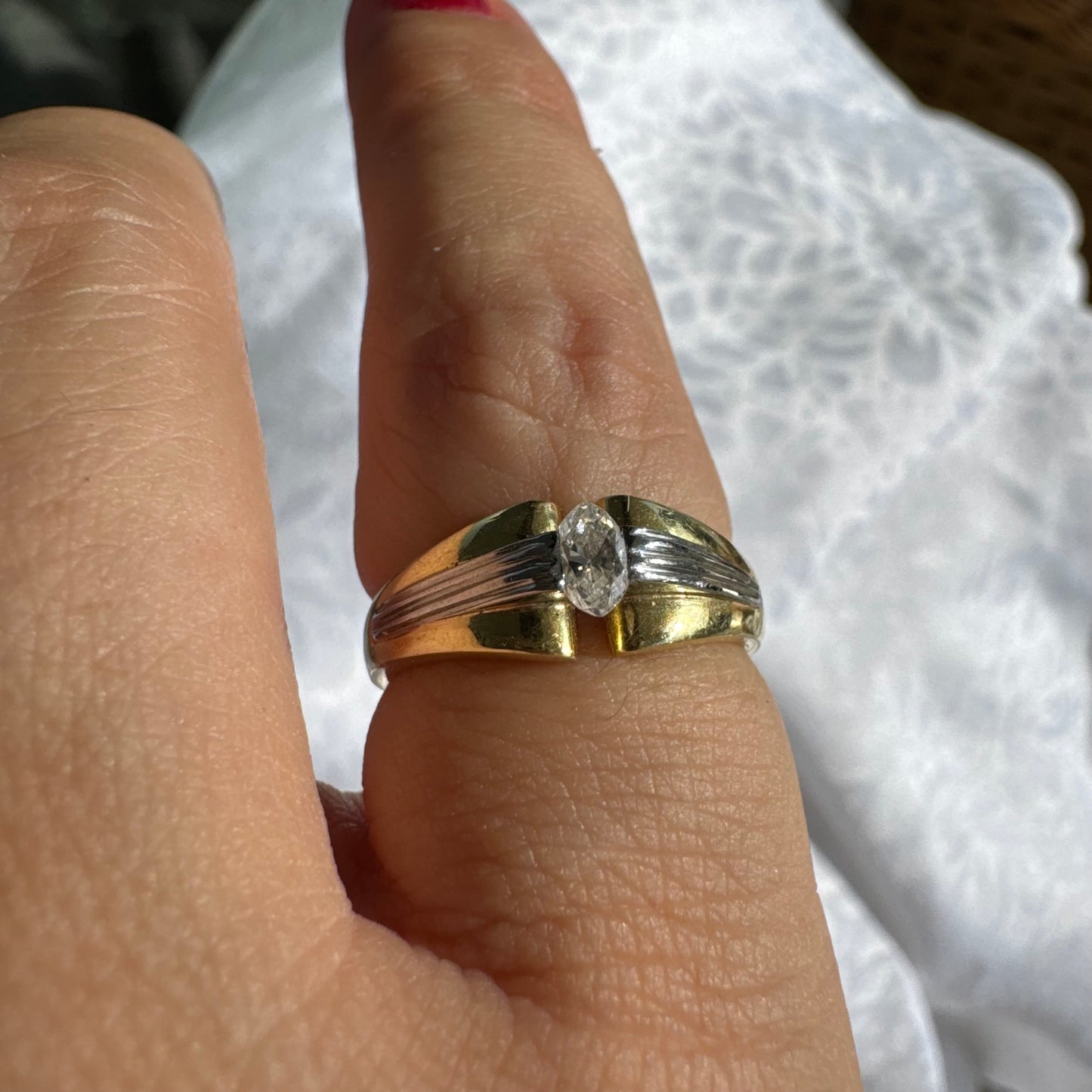 טבעת זהב 18 קראט בעיצוב דו-גוני של זהב צהוב ולבן, משובצת יהלום בחיתוך מרקיזה. 
