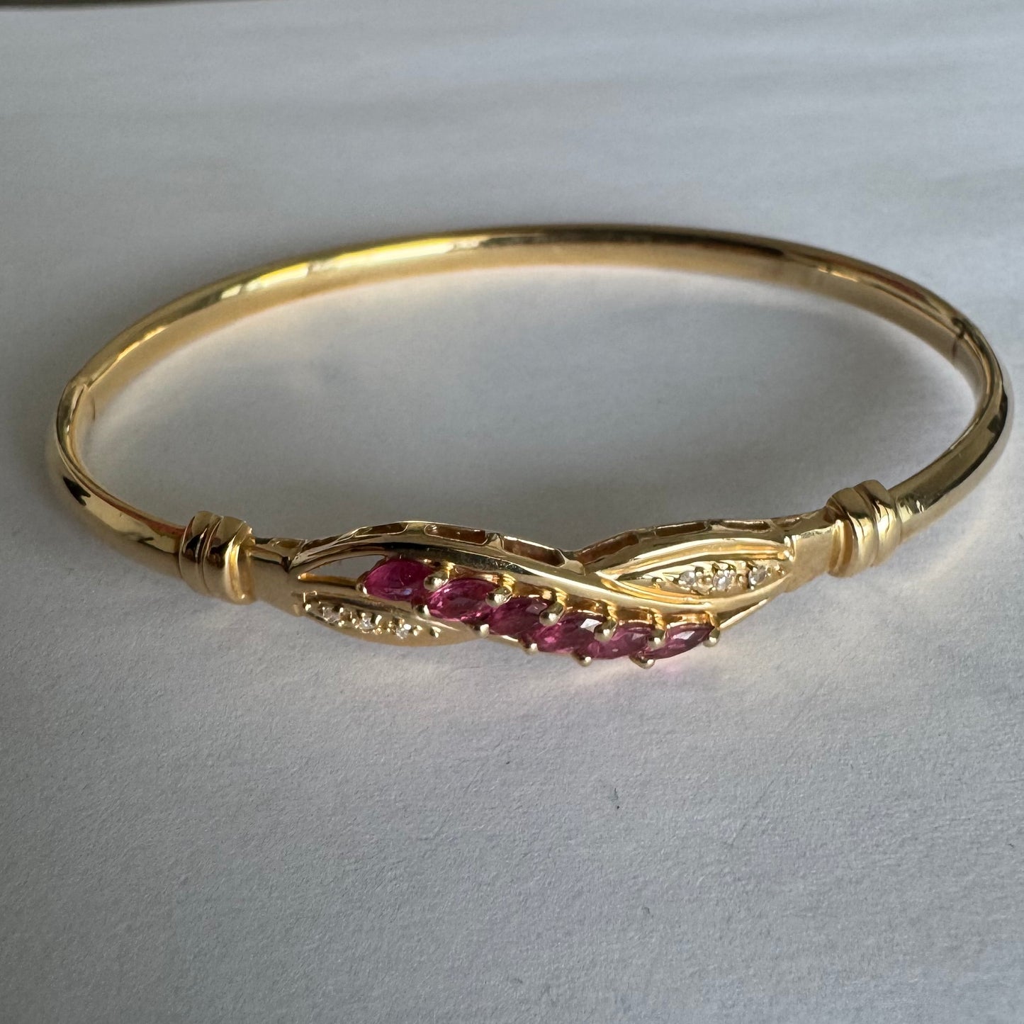 צמיד זהב צהוב 14 קראט משובץ אבני טורמלין בגוון ורוד-עמוק, בשילוב יהלומים המוסיפים ברק עדין.