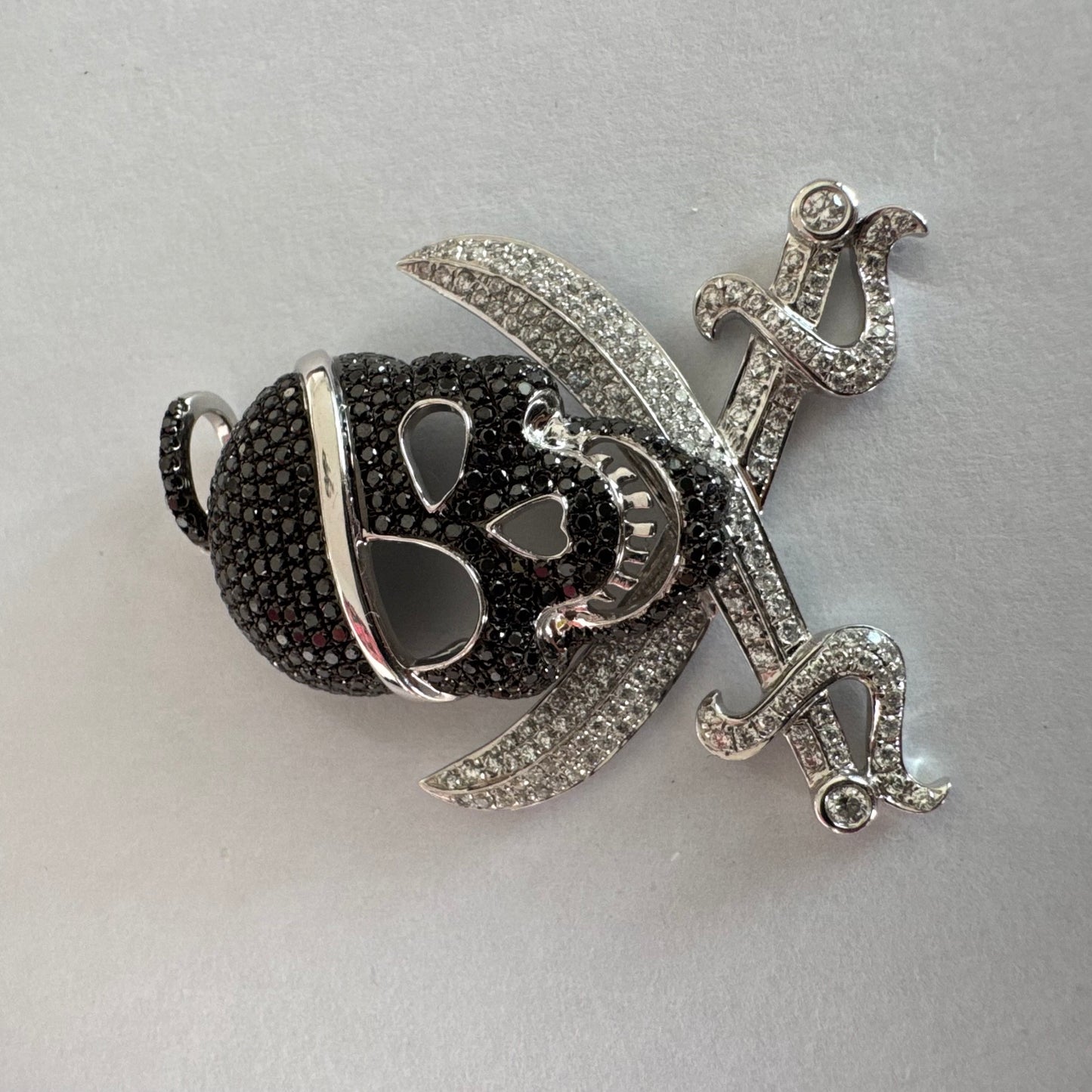 תליון זהב 14 קראט בצורת גולגולת/פיראט משובץ יהלומים לבנים ויהלומים שחורים בשיבוץ פאבה צפוף.