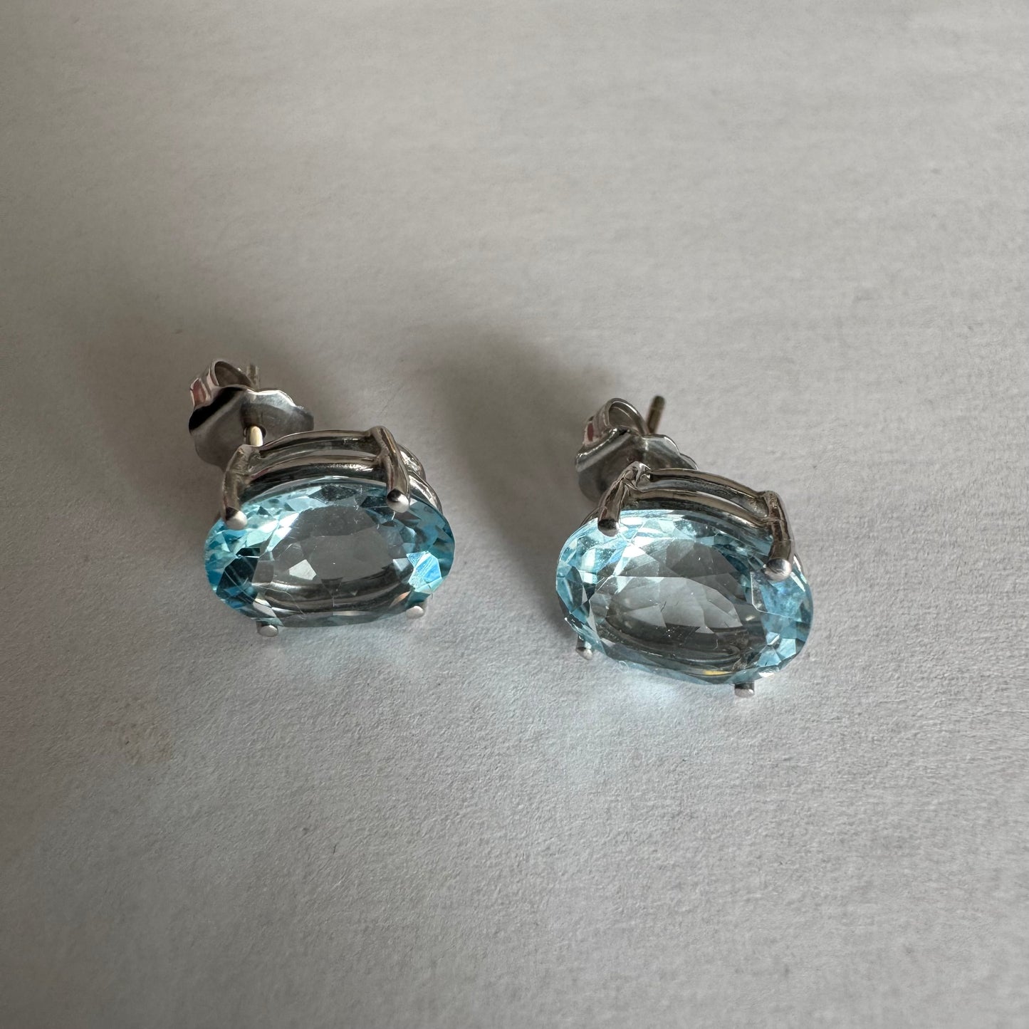 עגילי זהב לבן 14 קראט משובצים אבני אקוומרין אובליות בגוון תכלת-קריסטלי