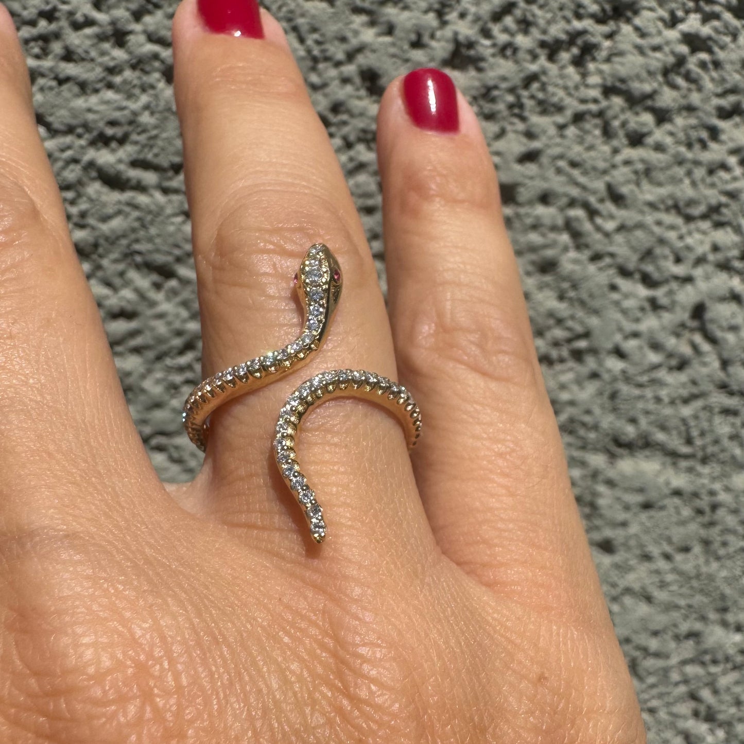14K gold wrap-around snake ring, fully set with sparkling Diamonds along its body and head, finished with Rubies eyes