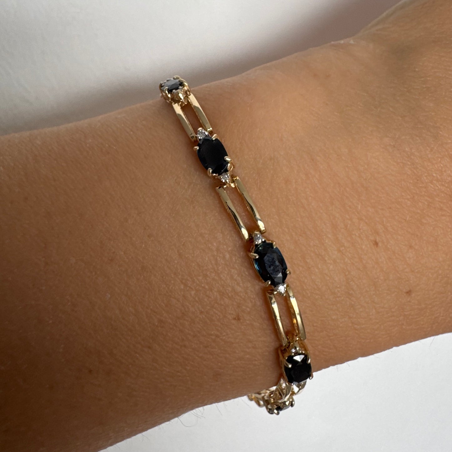 צמיד זהב צהוב 14 קראט משובץ אבני טופז כחולות בחיתוך אובלי, עם יהלומים המשובצים ביניהן להוספת ברק עדין.