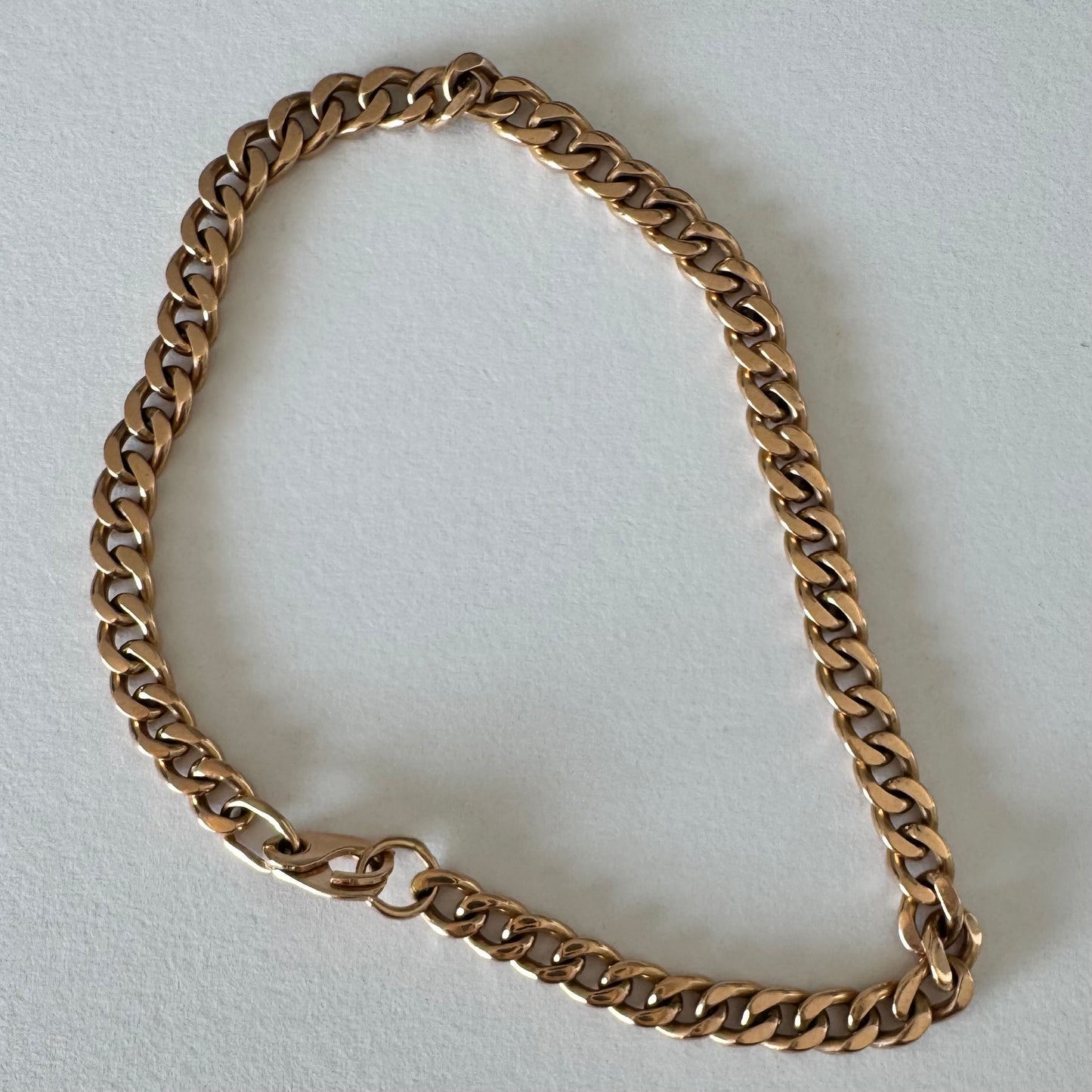 14K gold bracelet featuring a classic chain-link design with a sleek, elegant presence on the wrist.