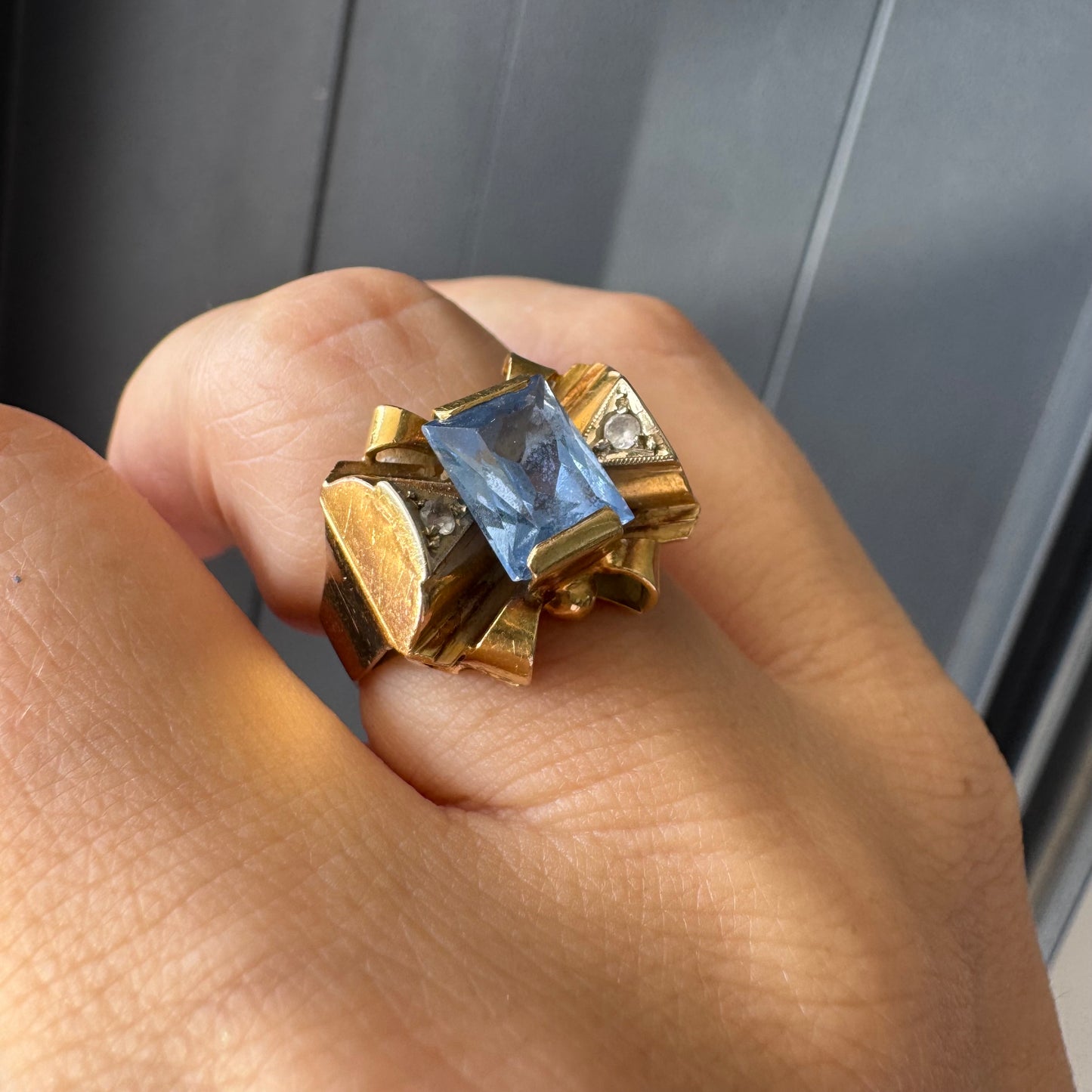 טבעת זהב צהוב 18 קראט בעיצוב פפיון משובצת אבן טופז כחולה בחיתוך מלבני במרכז
