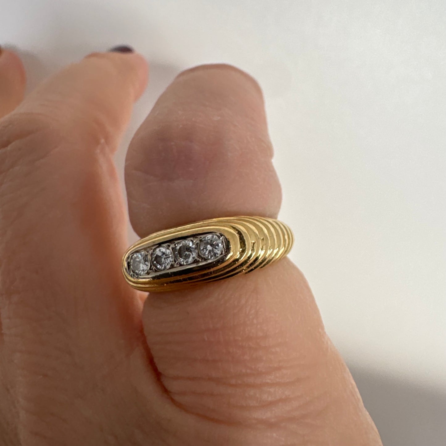 14K gold elongated oval ring set with five round Diamonds in a channel setting.