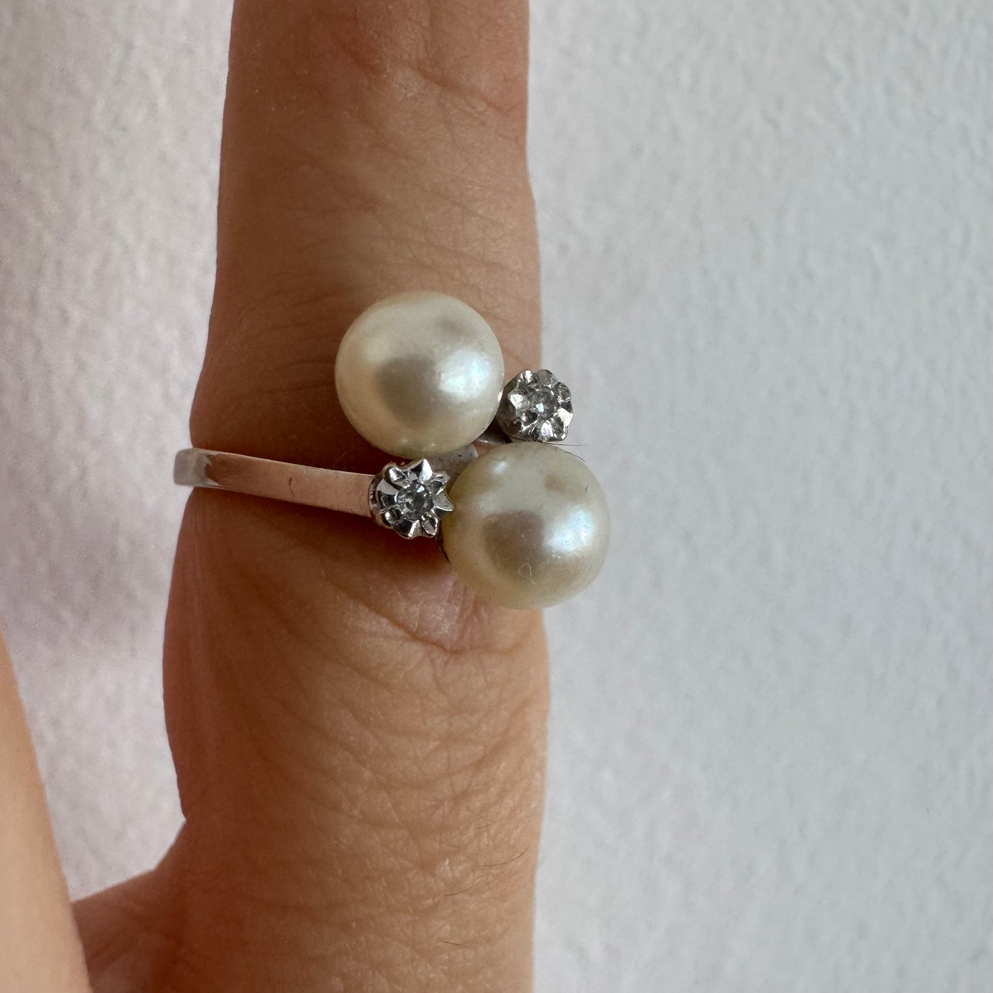 18K gold ring featuring a refined open design set with two luminous white Pearls and accented with two sparkling Diamonds