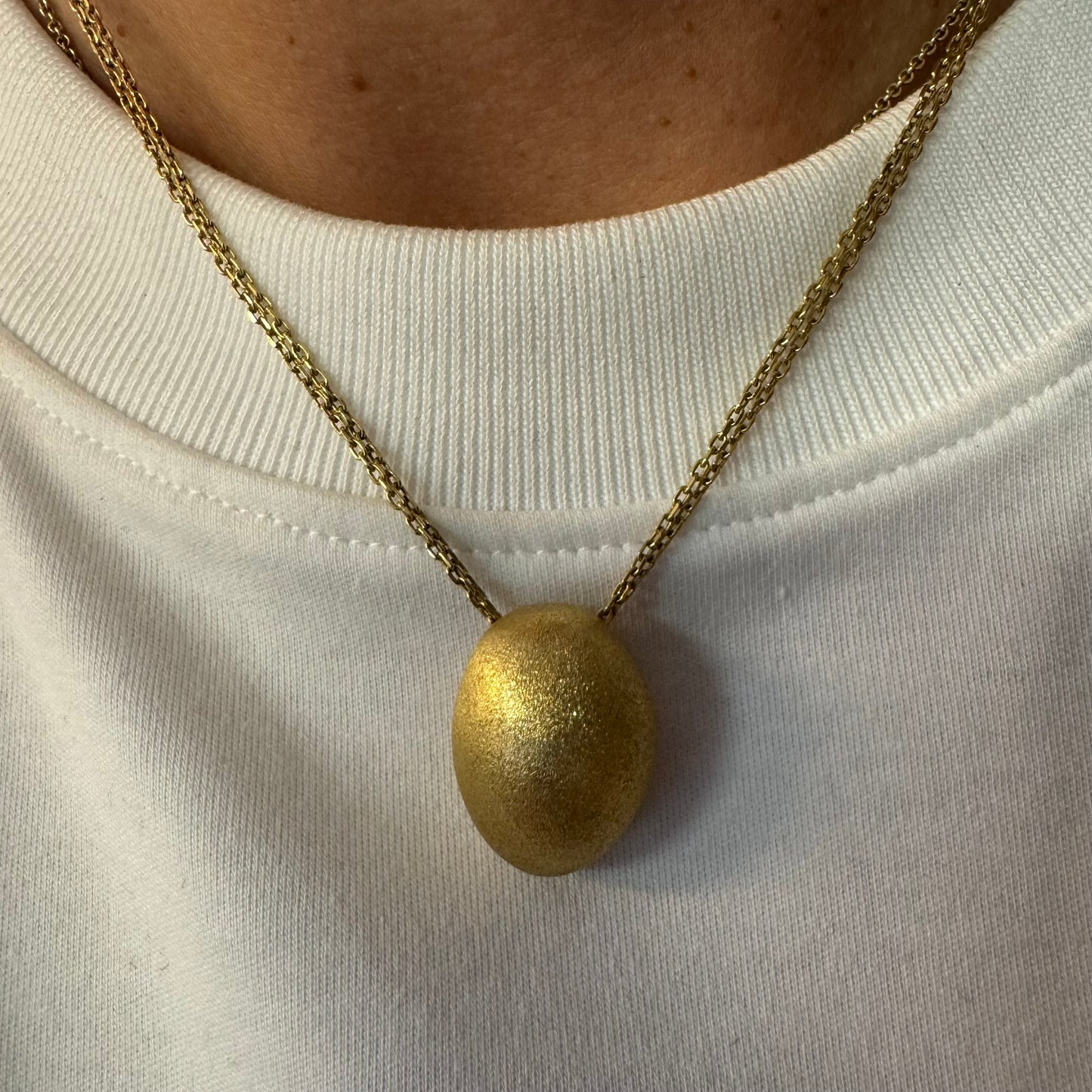 An elegant H.Stern 18K gold necklace featuring a bold oval pendant with a softly textured matte finish. 
(Golden Stones collection)