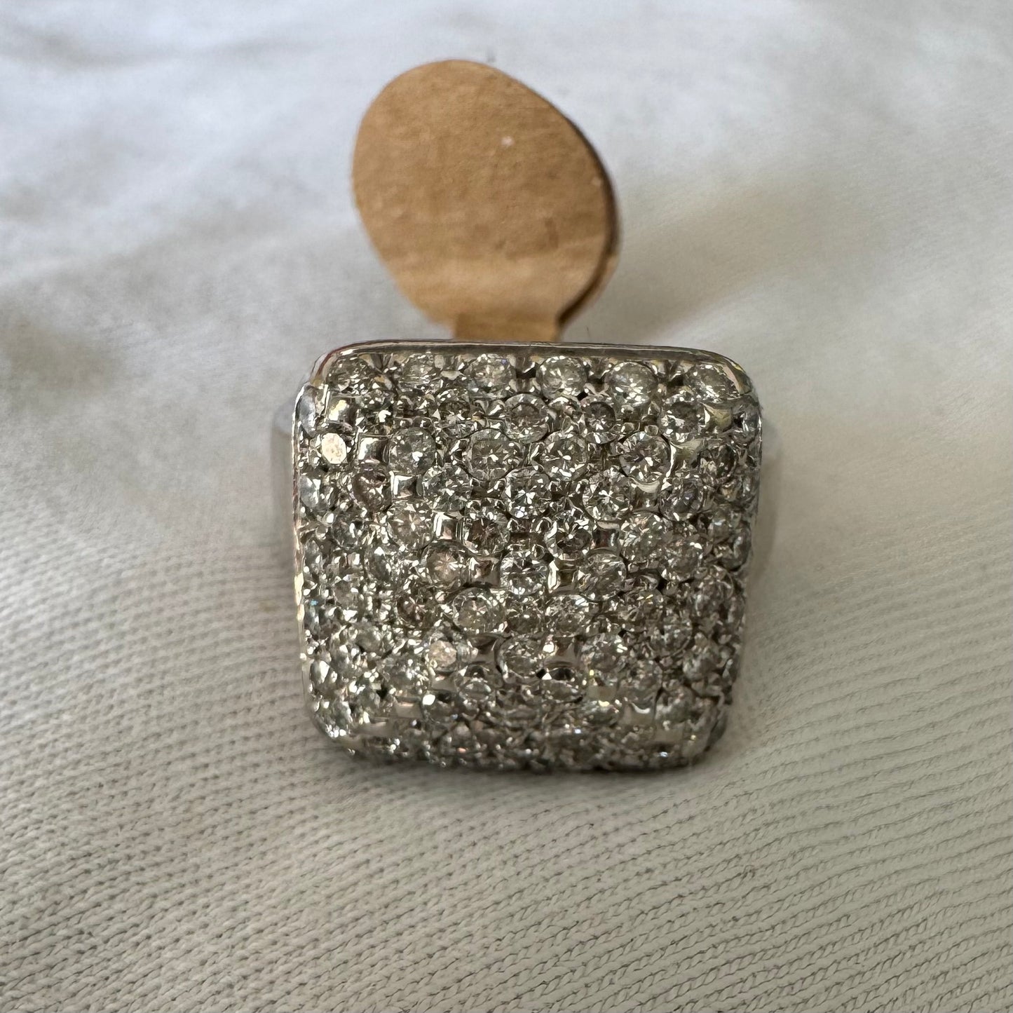 טבעת זהב לבן 18 קראט עם חלק עליון רחב בצורת ריבוע המשובץ כולו ביהלומים מנצנצים, ליצירת מראה יוקרתי ונוצץ.