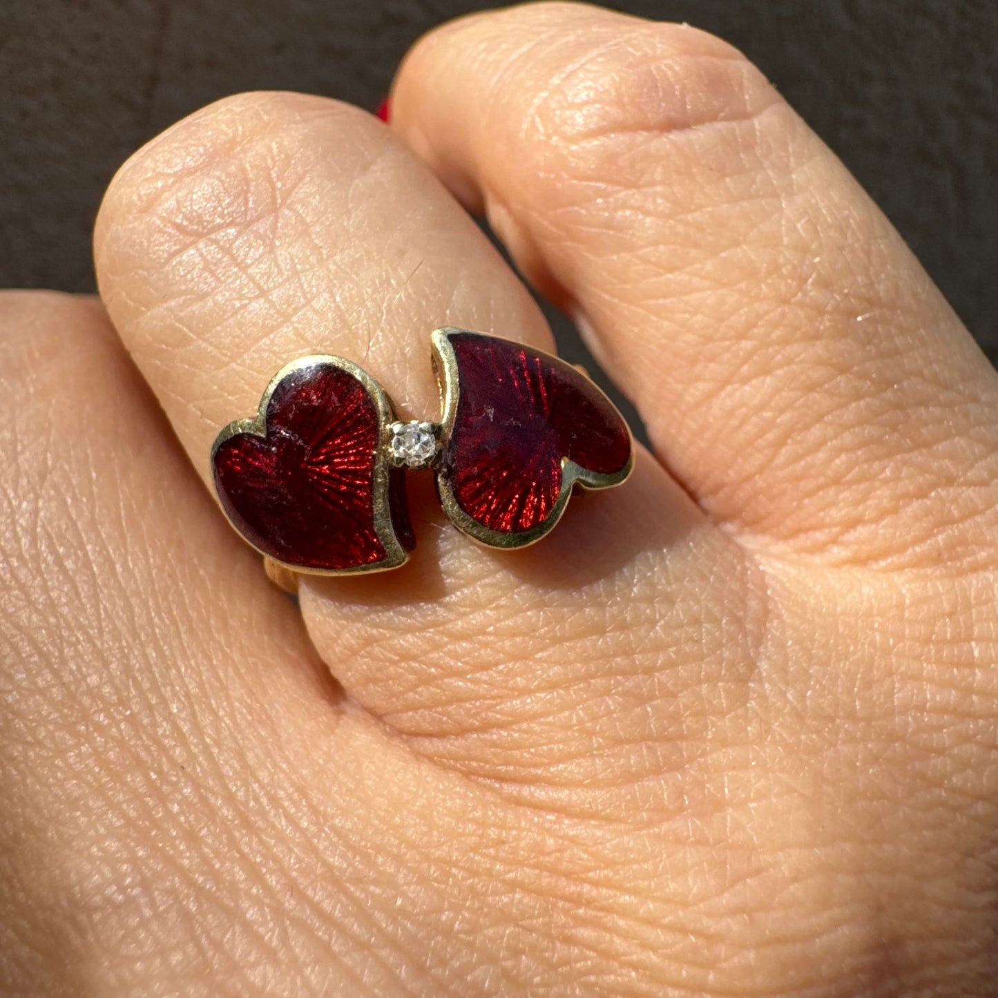 טבעת זהב צהוב 14 קראט “שני לבבות מחוברים״ מצופים אמייל אדום ויהלום משובץ במרכז
