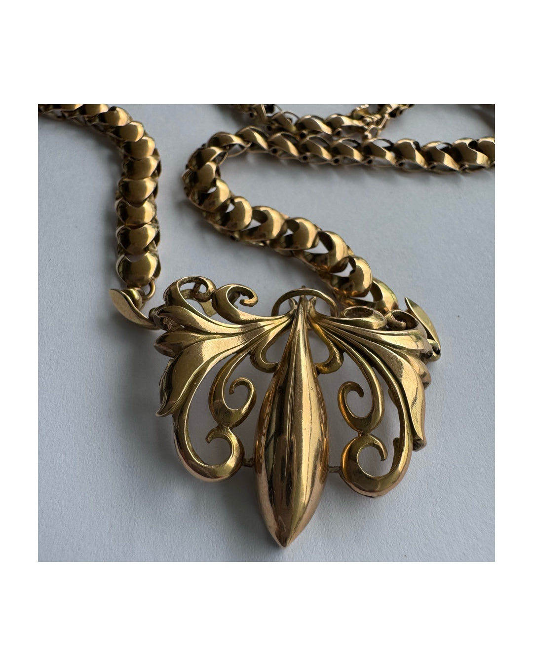 שרשרת זהב 14 קראט בעלת עיטור פלר דה ליס (Fleur-de-lis) אמנותי, המעוצב בקווים מעוגלים של עלי שושן בסגנון אר נובו.