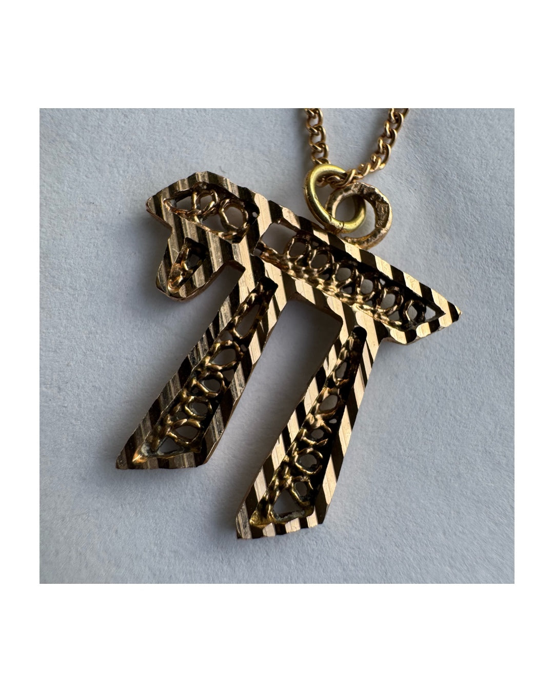 שרשרת זהב אדום 14 קראט עם תליון “חי״, בעיצוב גרפי ובעל נוכחות.