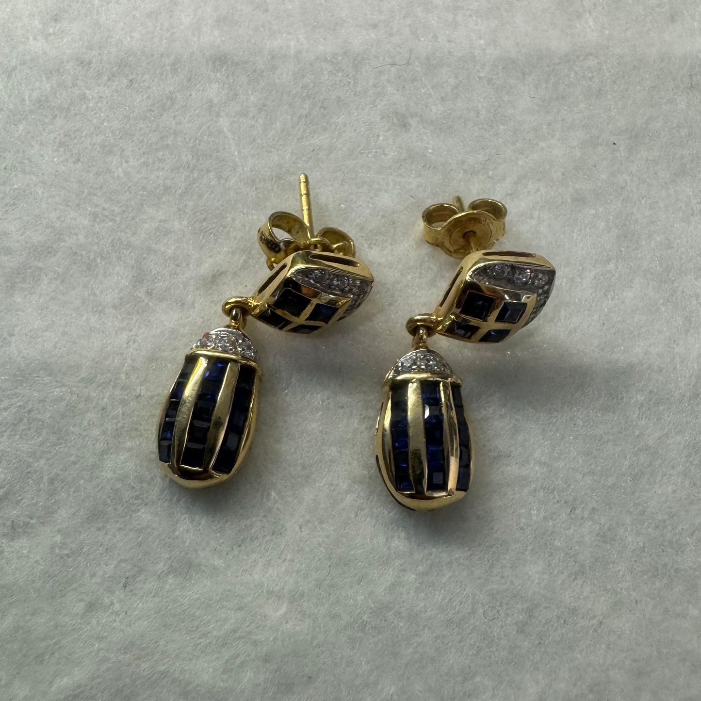 18K old drop earring set with deep blue Sapphires in a geometric pattern, accented with sparkling Diamonds.