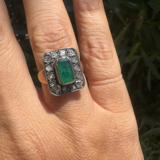 18K gold ring set with a rectangular Emerald and framed by a halo of rose-cut Diamonds